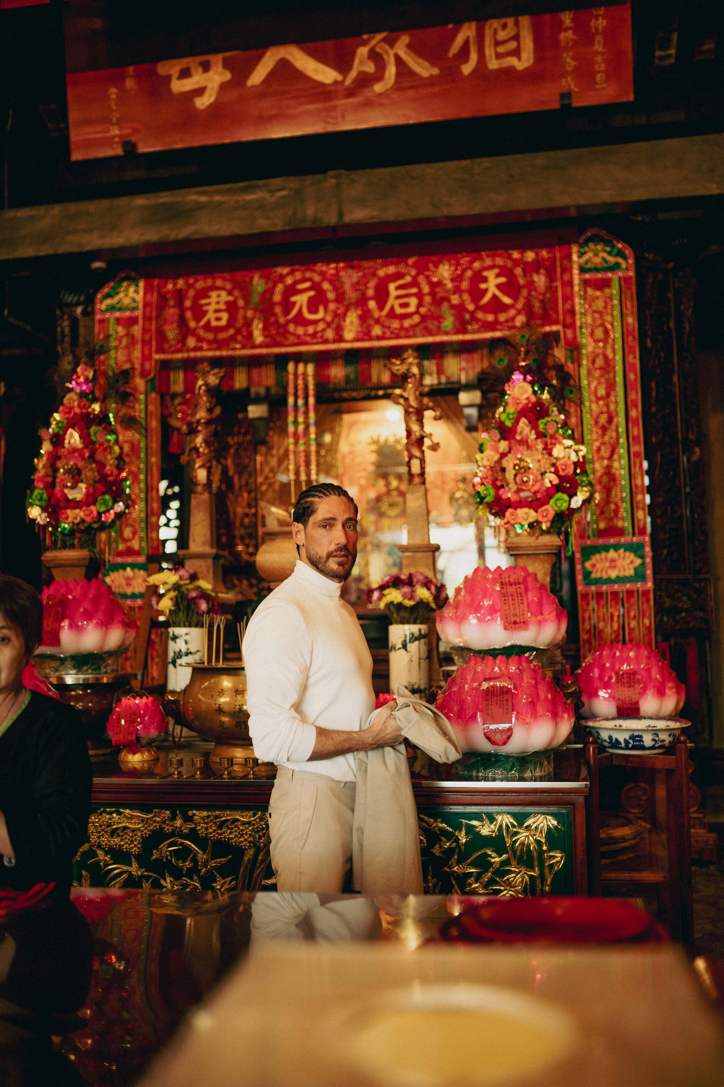 Environmental portrait of Angelo Rodrigues at A-Ma Temple, Macau, surrounded by incense smoke, ritual objects, and temple details. Retrato ambiental de Angelo Rodrigues no Templo de A-Má, em Macau, envolvido por fumo de incenso, objetos rituais e det