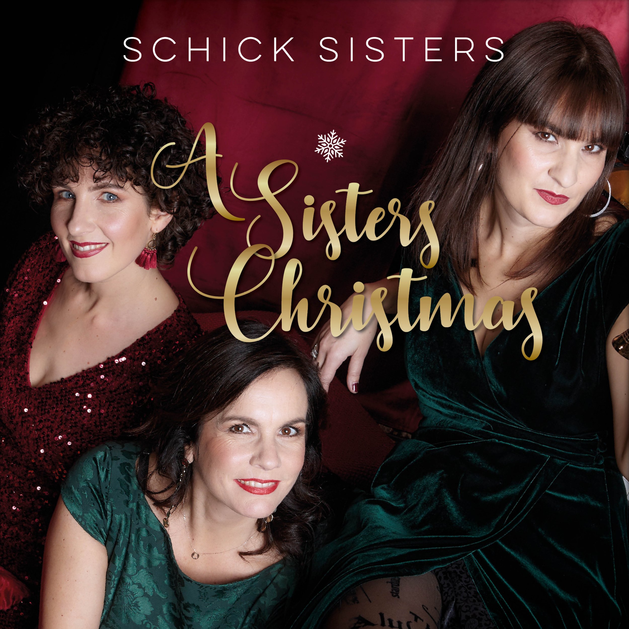 Drei Frauen sitzen auf einem Sofa, tragen festliche Kleider, umgeben von Weihnachtsdeko, mit dem Text 'A Sisters Christmas' und 'Schick Sisters' im Bild.