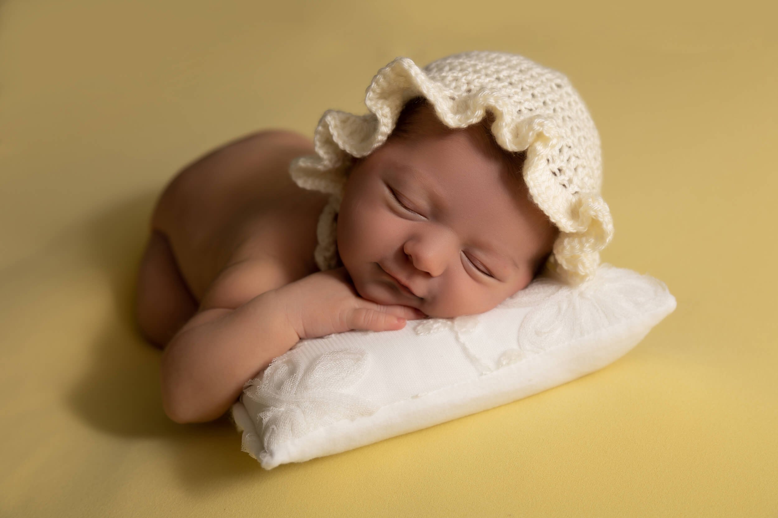 newborn beanbag poses photographry chin on hand.jpg