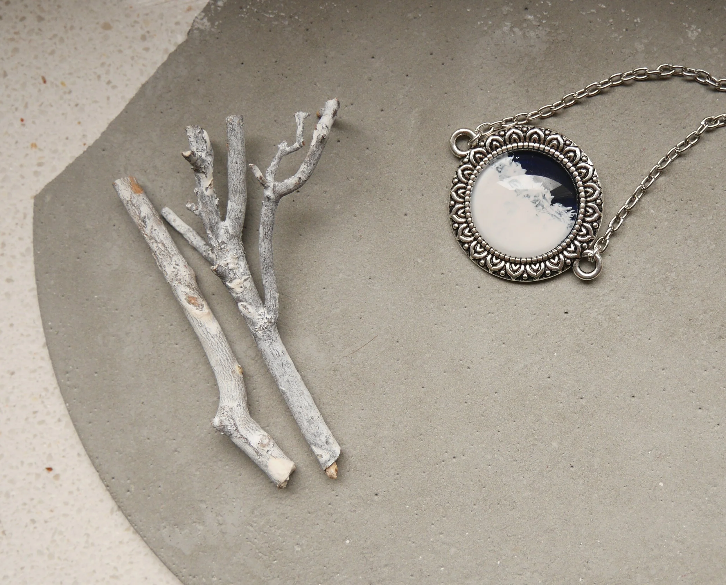 Silberne Halskette mit rundem, handbemaltem Glascabochon, dunkelblau und weiß, in verzierter Fassung