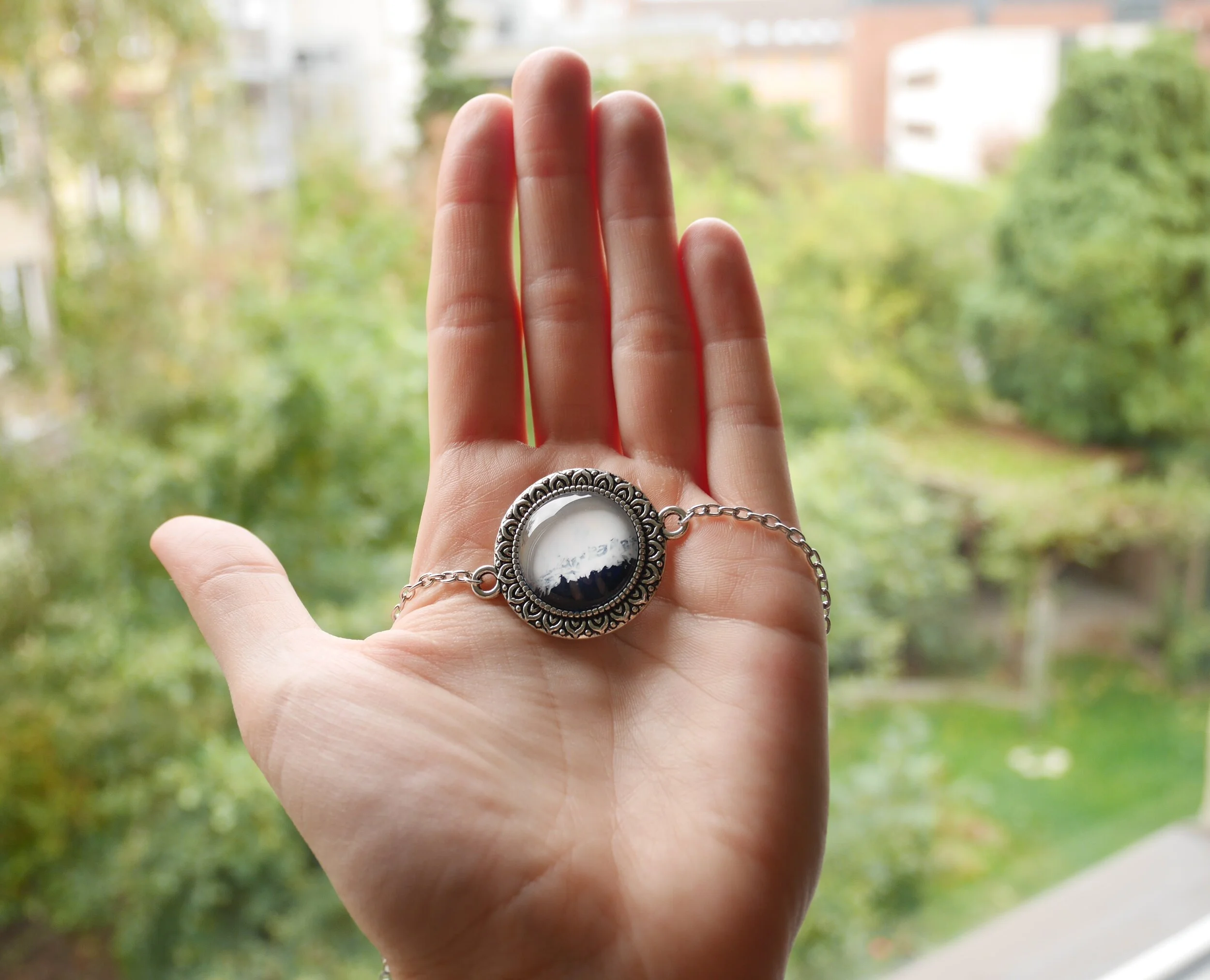 Silberne Halskette mit rundem, handbemaltem Glascabochon, dunkelblau und weiß, in verzierter Fassung,