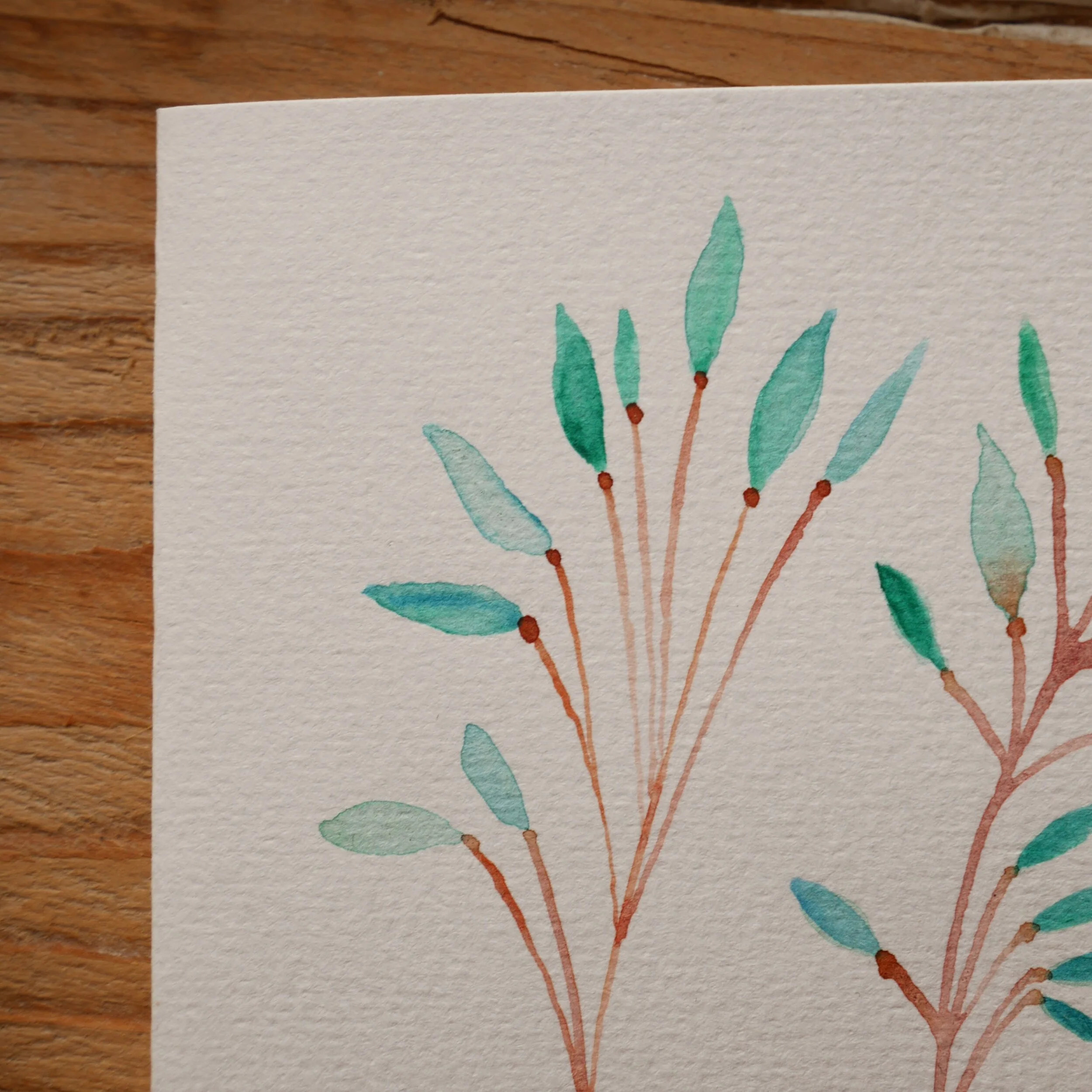 Klappkarte aus Papier mit Aquarellzeichnung und mildgrünem Umschlag Zwei zarte braune Zweige mit Pastellgrünen Blättern