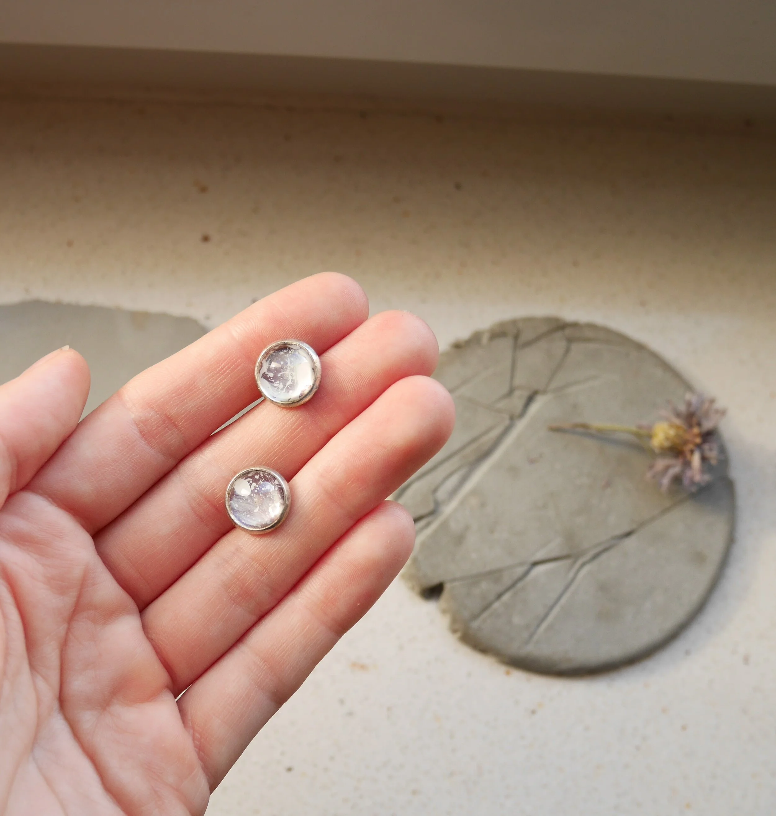 kleine, runde, silberne Ohrstecker mit handbemalten Glascabochons in blass violetten Tönen