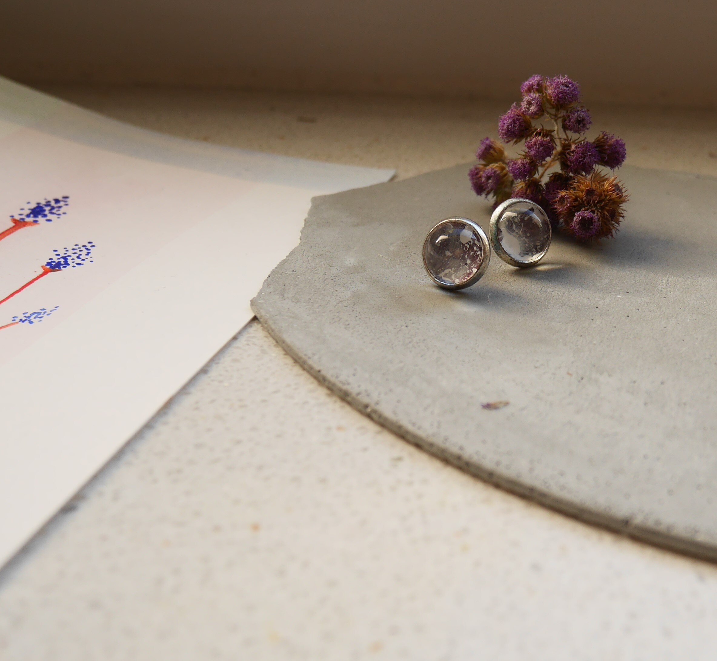 kleine, runde, silberne Ohrstecker mit handbemalten Glascabochons in blass violetten Tönen