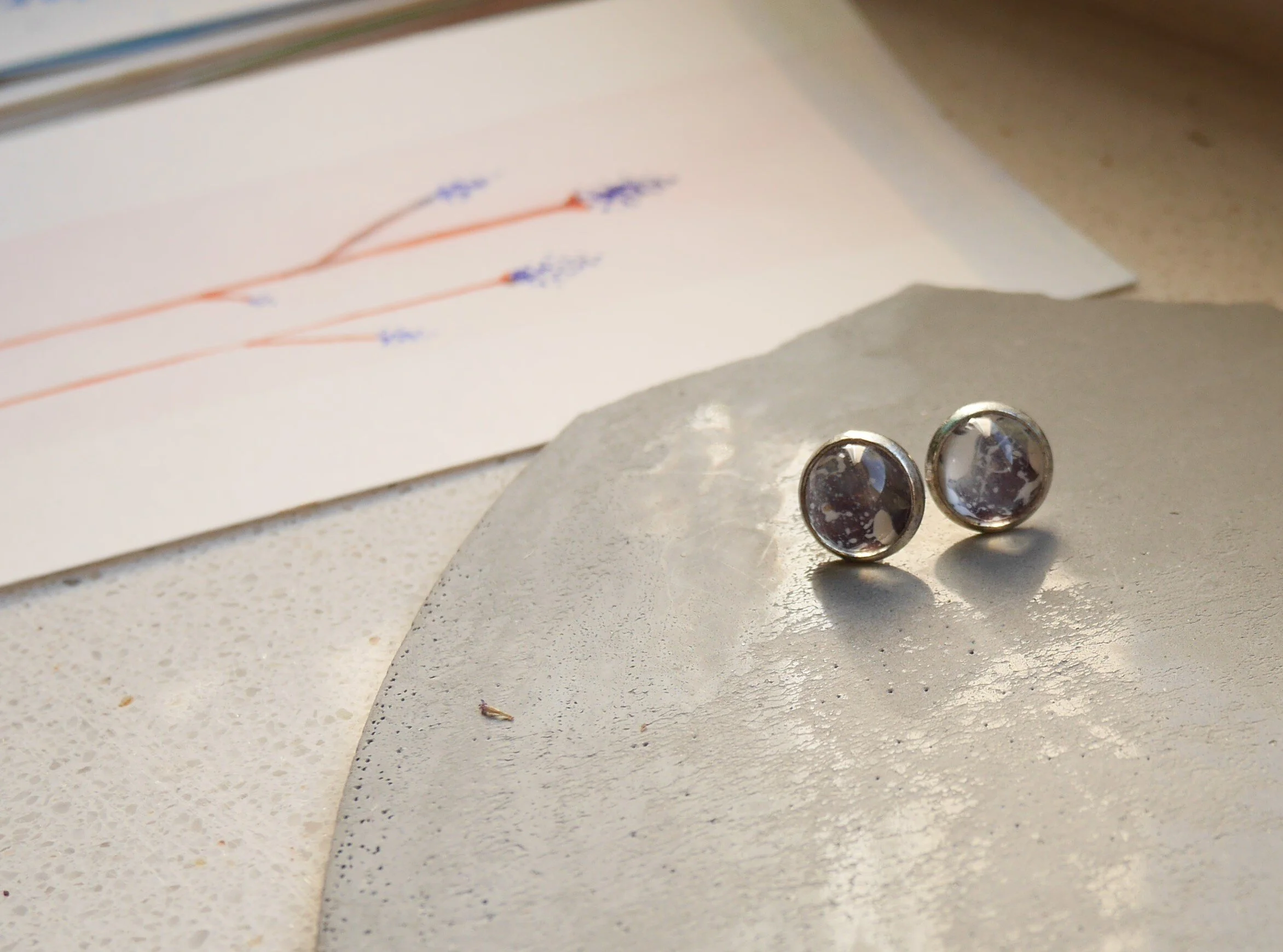 kleine, runde, silberne Ohrstecker mit handbemalten Glascabochons in blass violetten Tönen