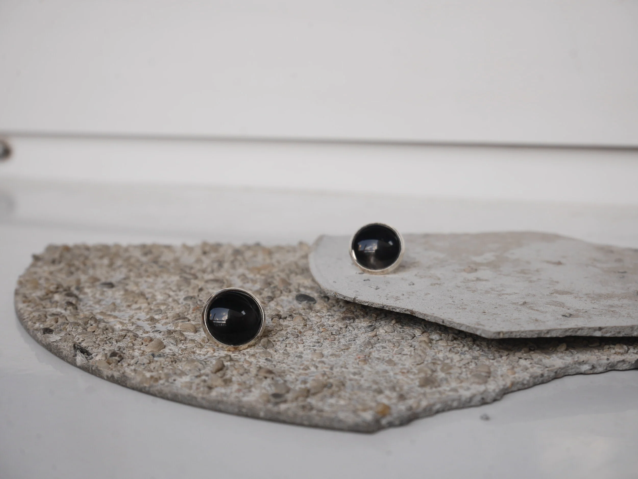 silberne Ohrstecker mit runden, schwarzen Glascabochons