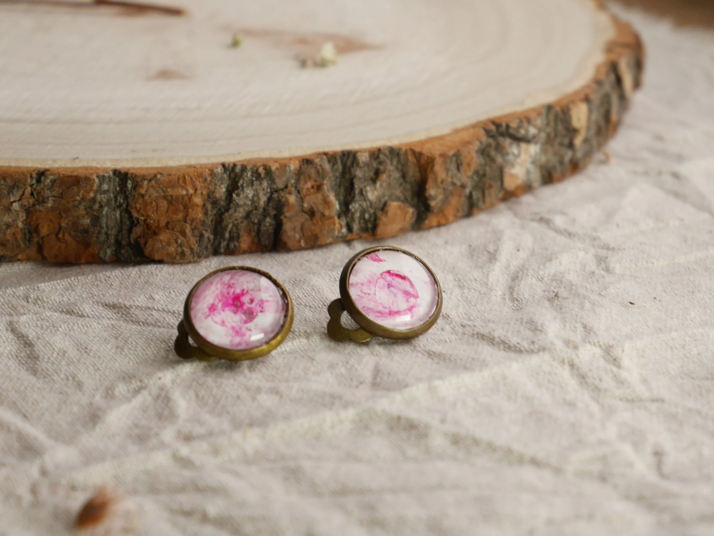 bronzefarbene, runde Ohrclips mit pink-weiß bemalten Glassteinen