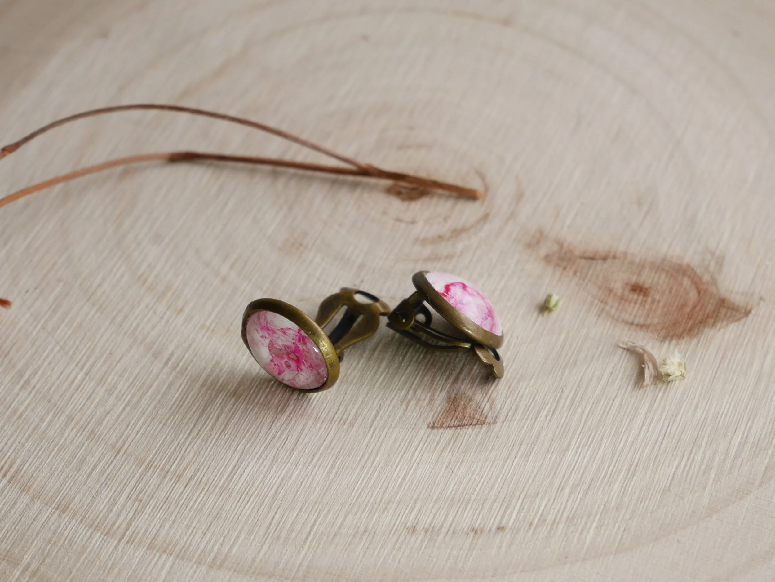 bronzefarbene, runde Ohrclips mit pink-weiß bemalten Glassteinen