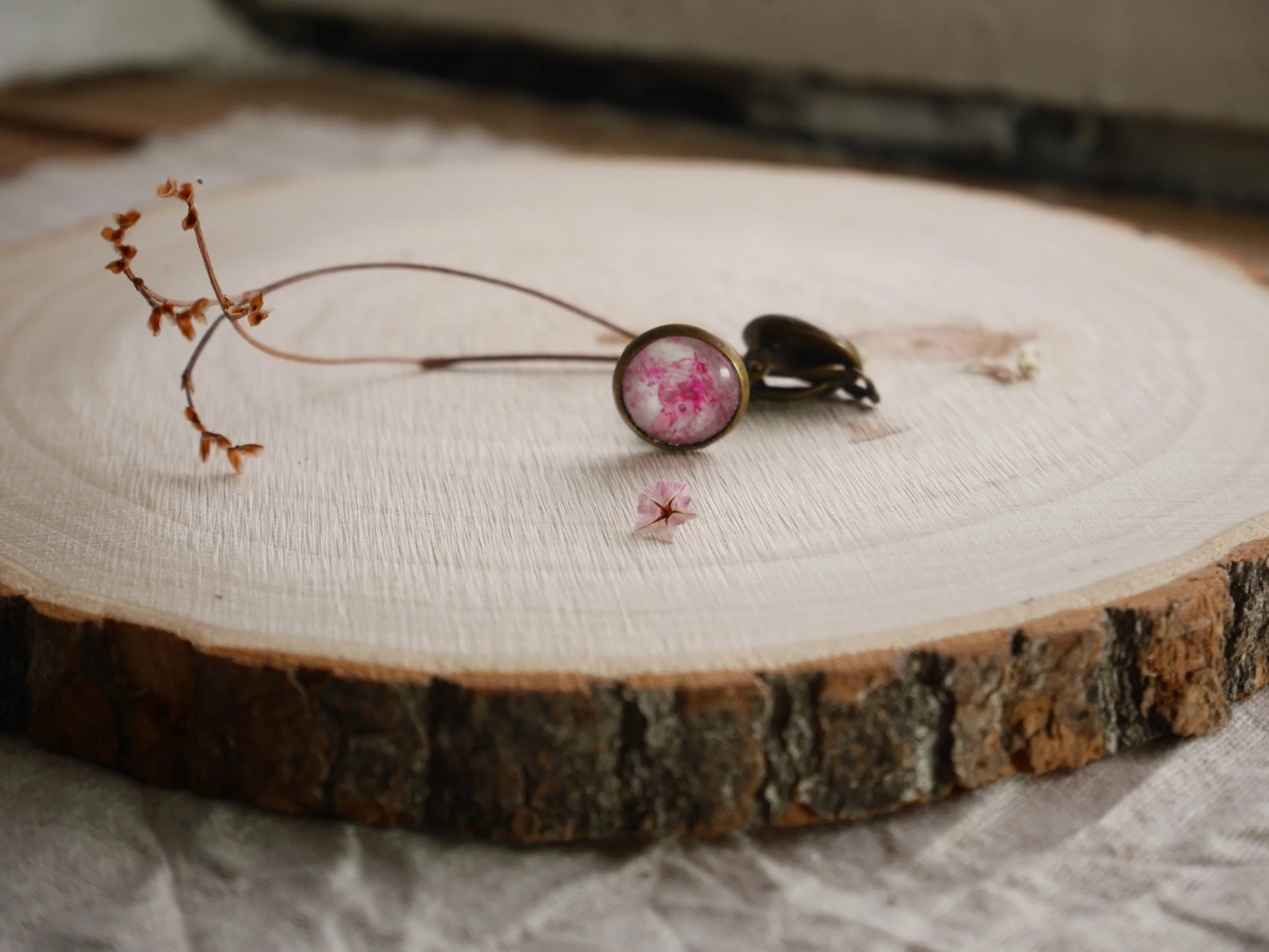 bronzefarbene, runde Ohrclips mit pink-weiß bemalten Glassteinen