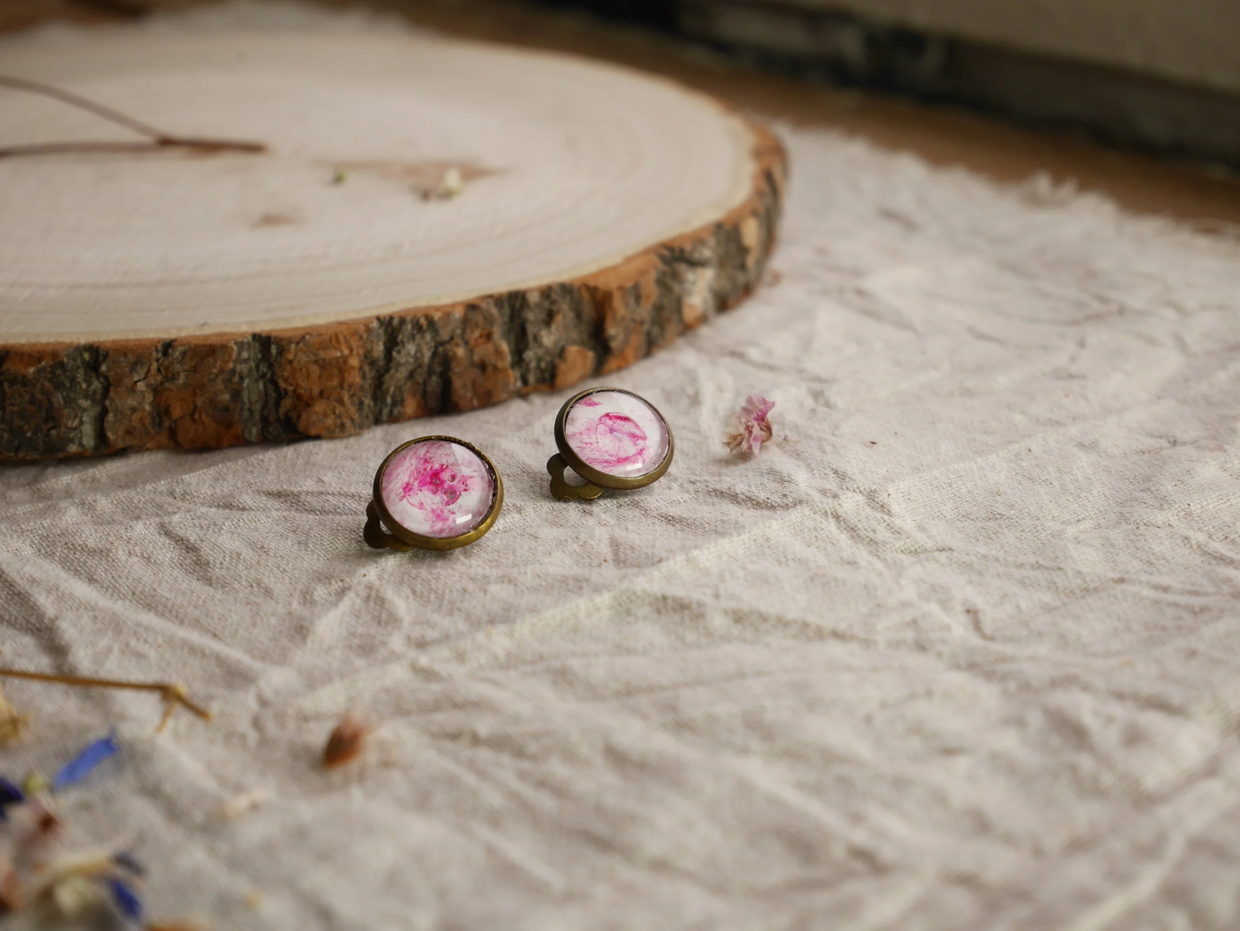 bronzefarbene, runde Ohrclips mit pink-weiß bemalten Glassteinen