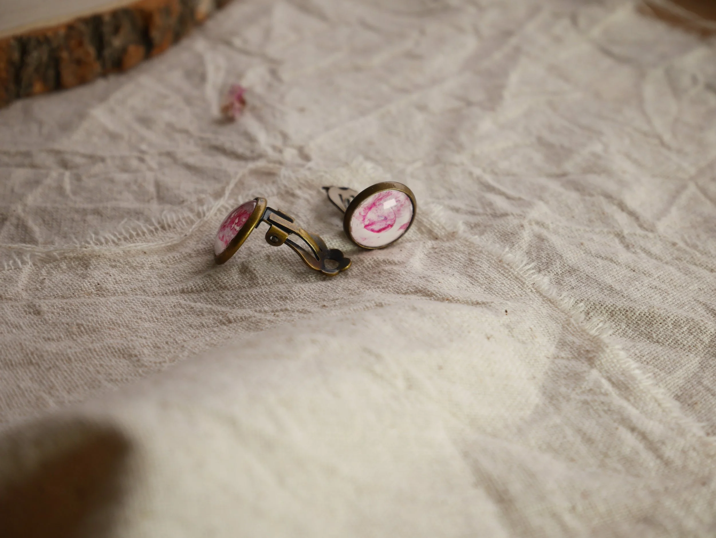 bronzefarbene, runde Ohrclips mit pink-weiß bemalten Glassteinen