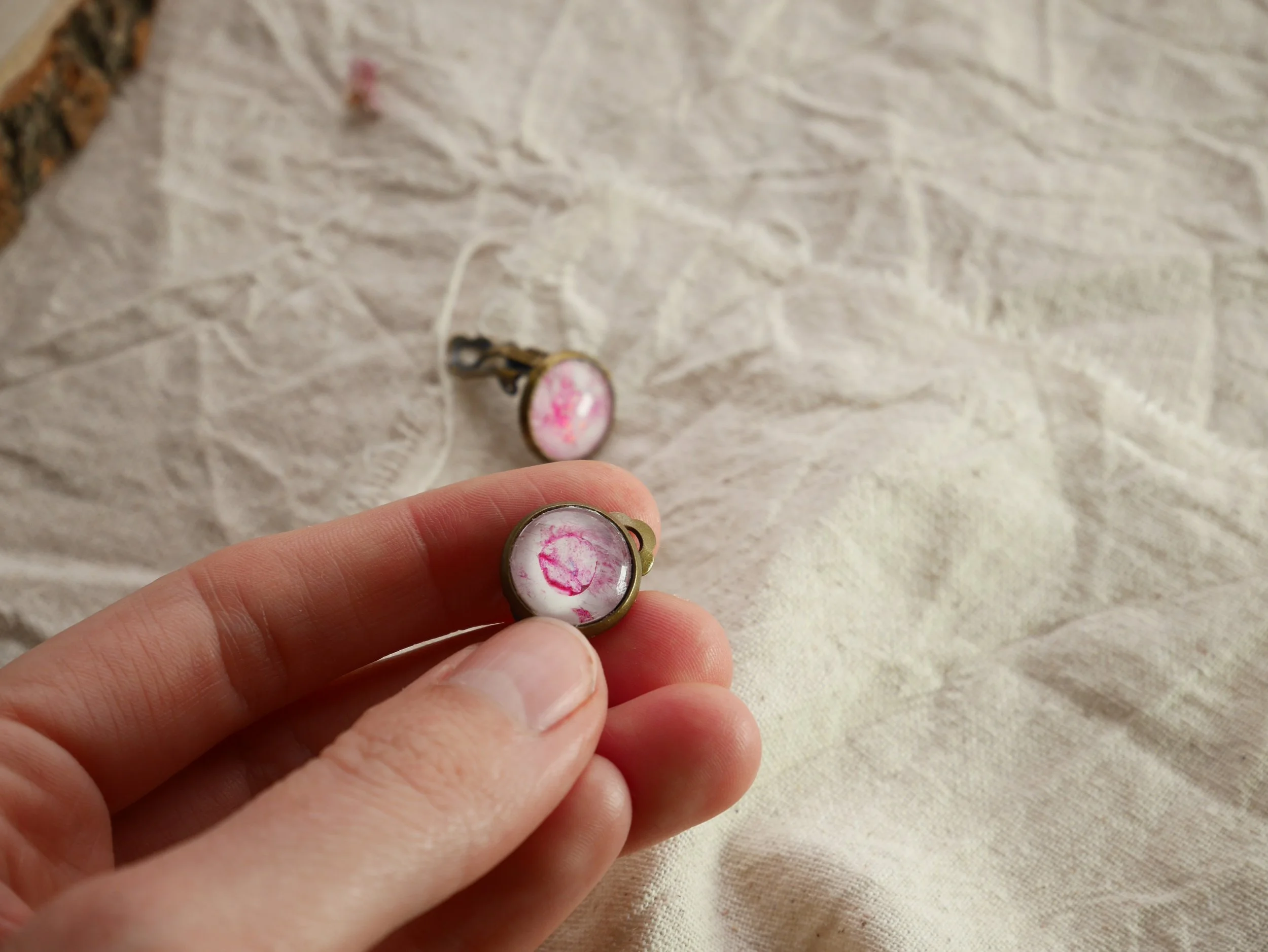 bronzefarbene, runde Ohrclips mit pink-weiß bemalten Glassteinen