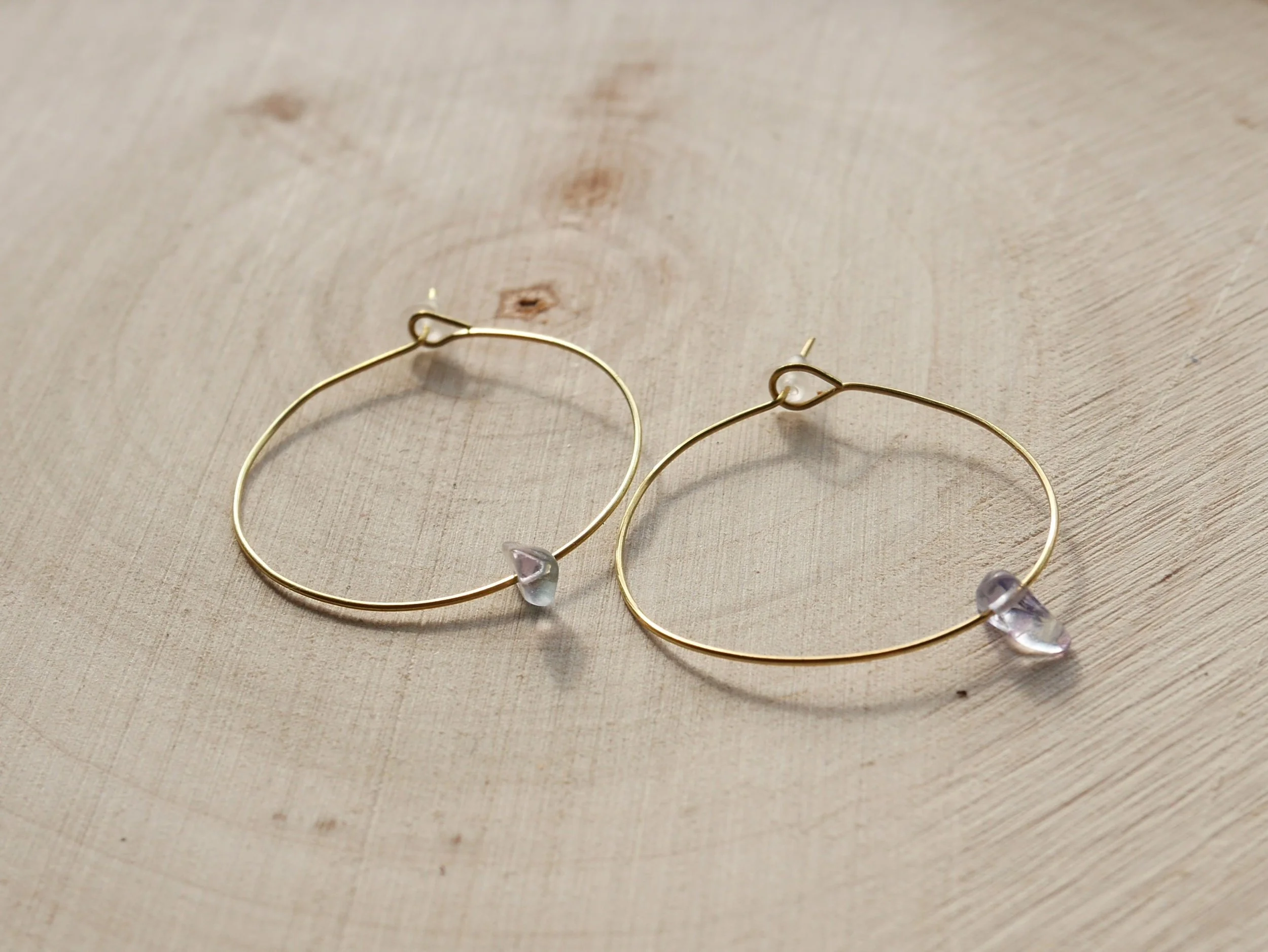 goldene Creolen mit kleinen, durchsichtigen Fluoritsplittern mit blassviolettem Schein