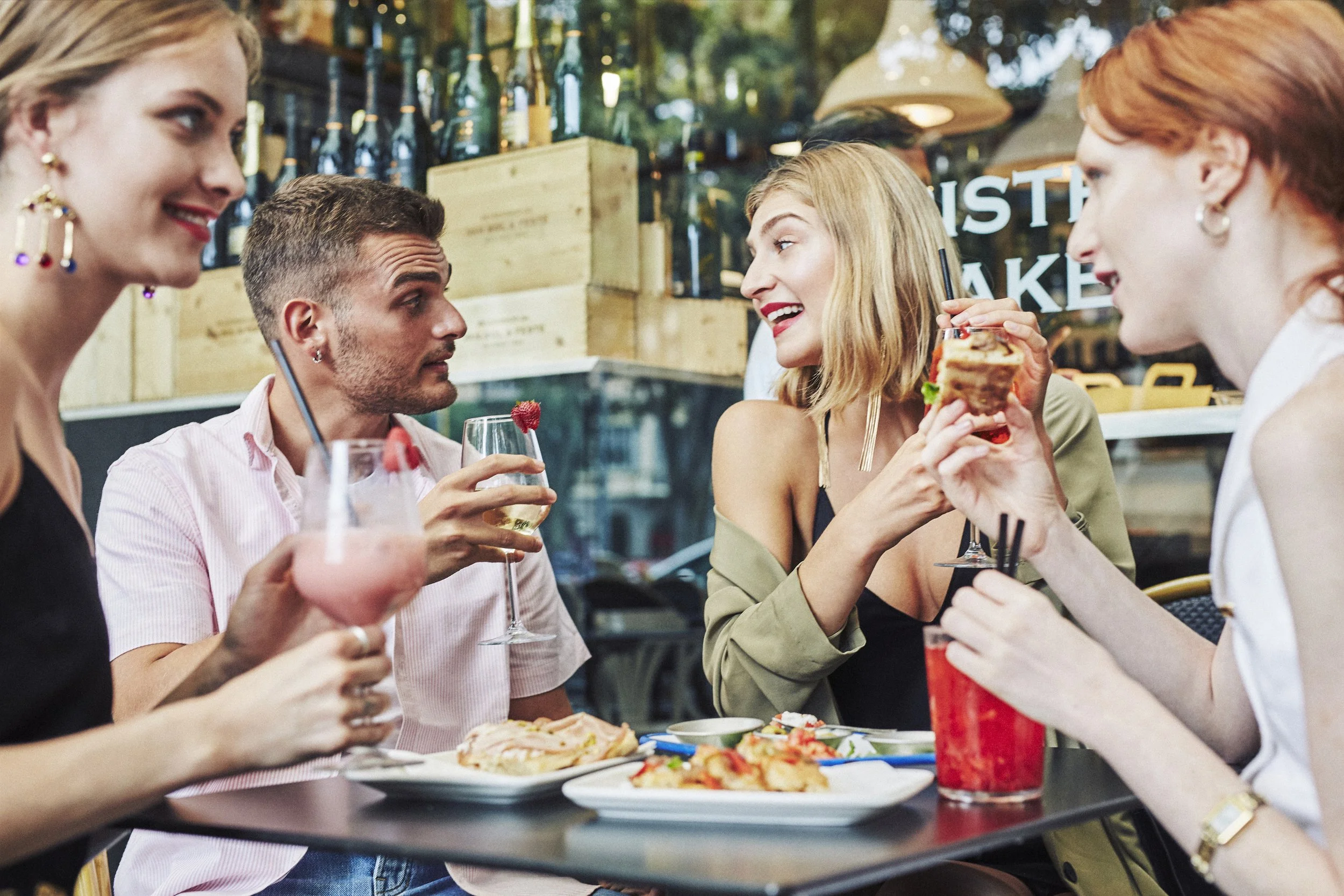 Group of friends enjoying drinks and snacks at an outdoor café.