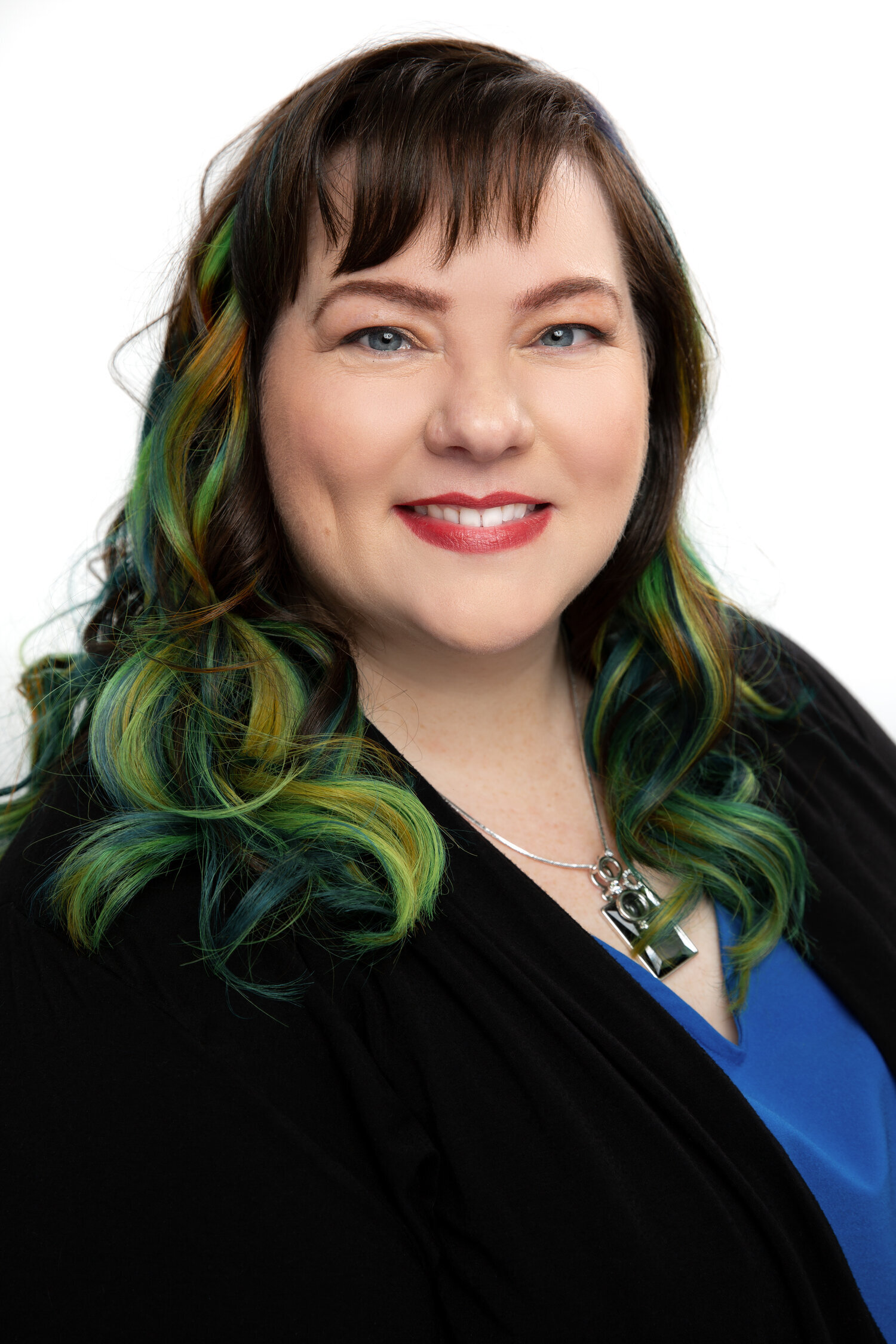 Smiling woman with colorful hair and black blazer