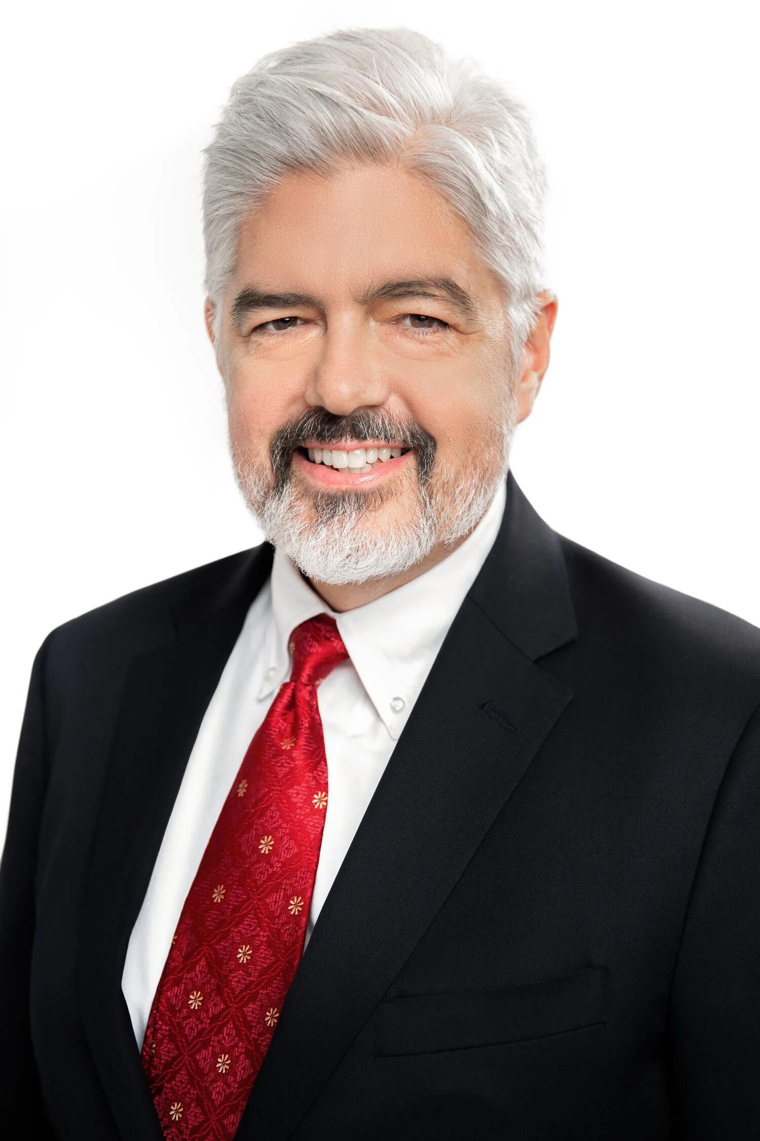 Smiling man with gray hair in suit and red tie