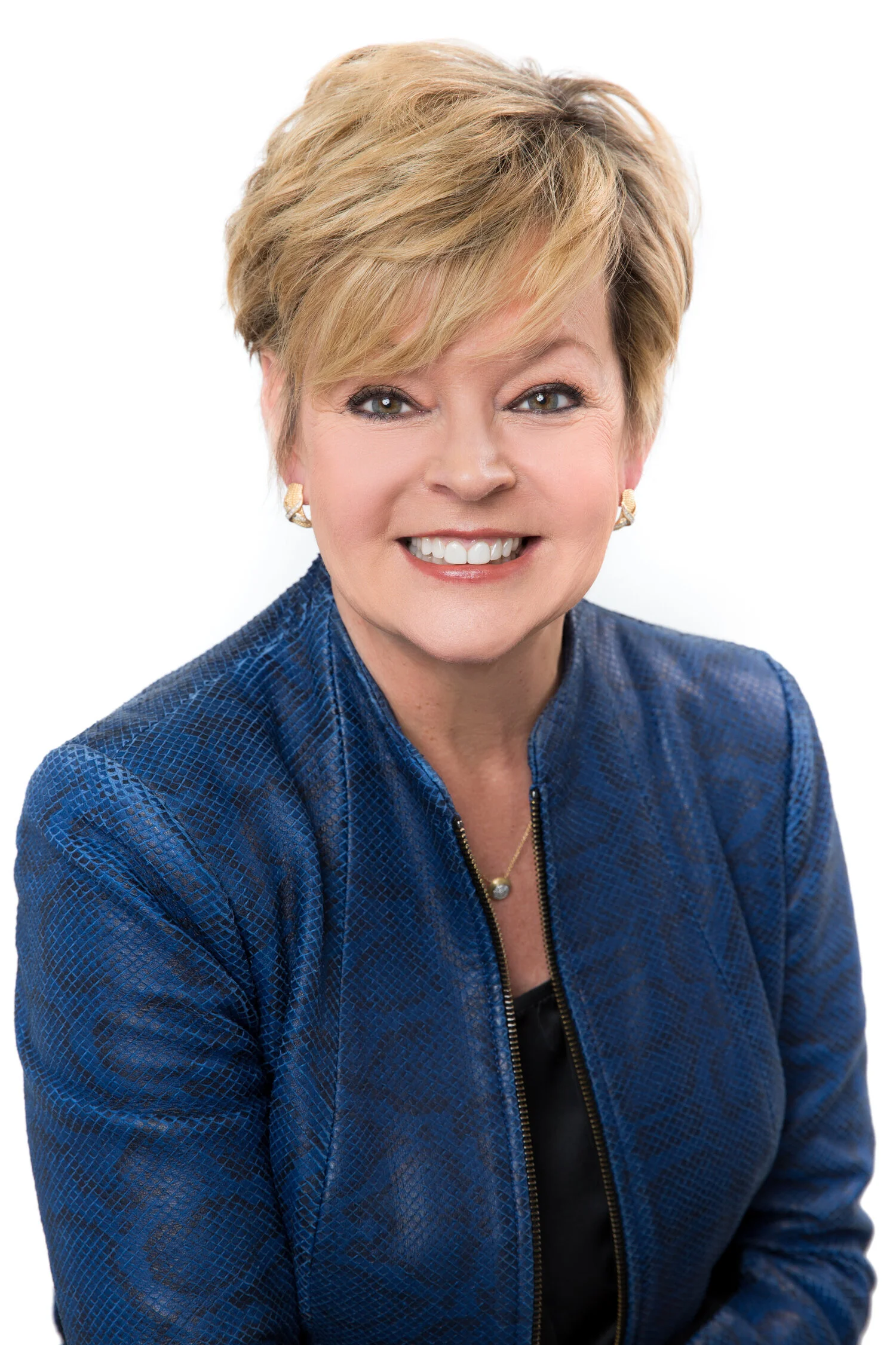 Smiling woman with short blonde hair wearing a blue jacket