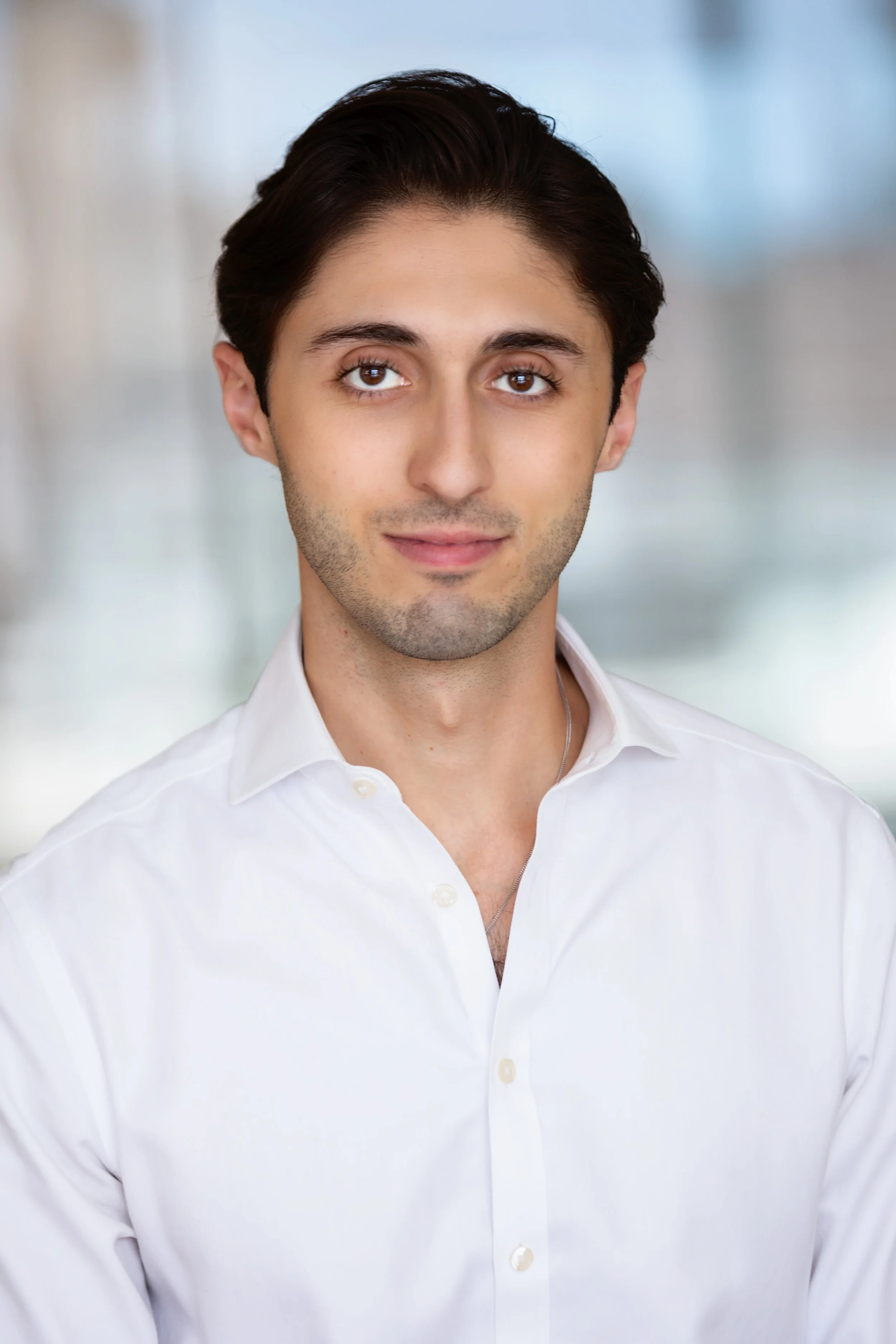 Portrait of a person in a white shirt with a blurred background.
