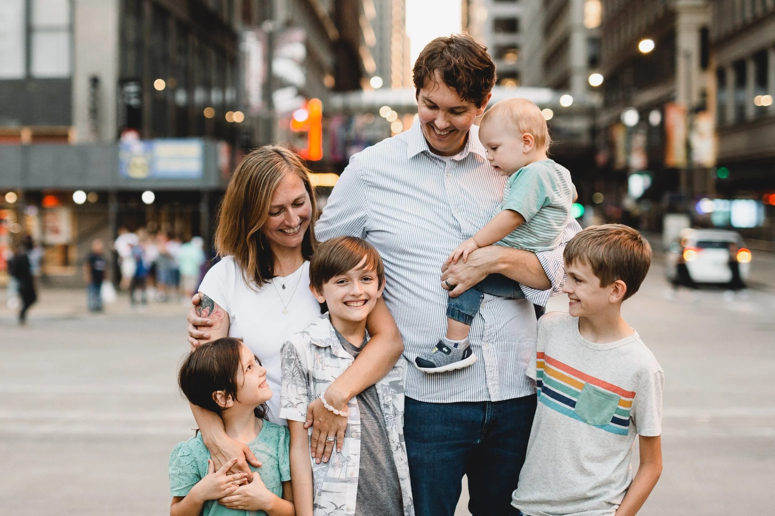 mom and dad with 4 kids standing together on busy street in downtown chicago