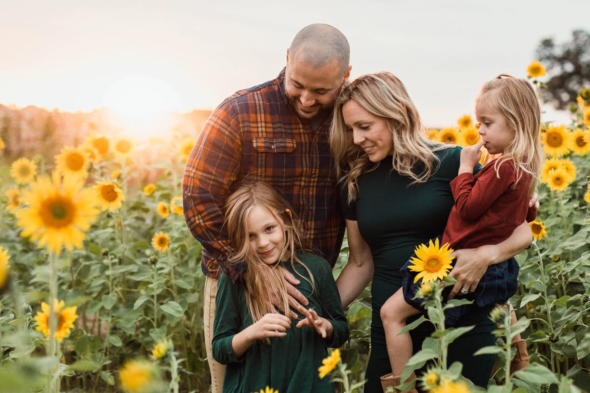 family with two young girls in Thompson Strawberry farm sunflower field