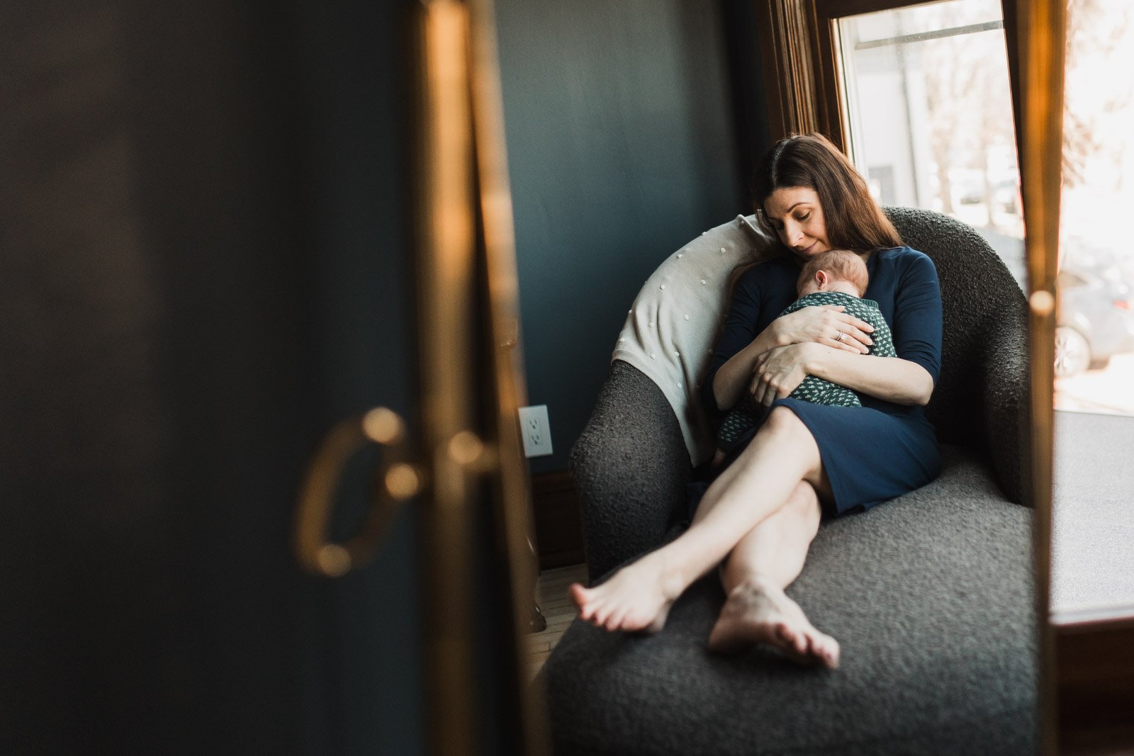 mirror reflection of new mom holding newborn 