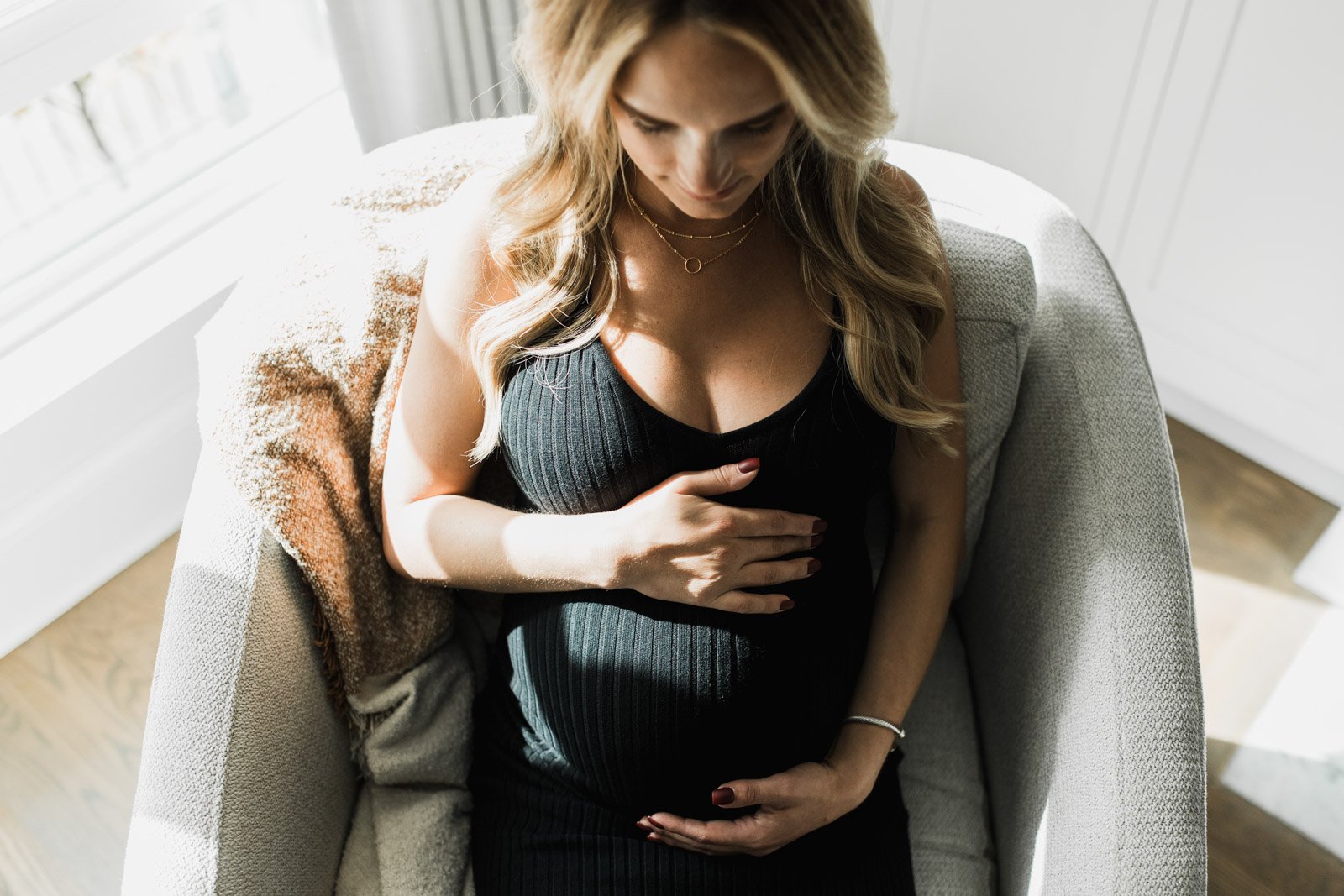 woman looking down at her pregnant belly