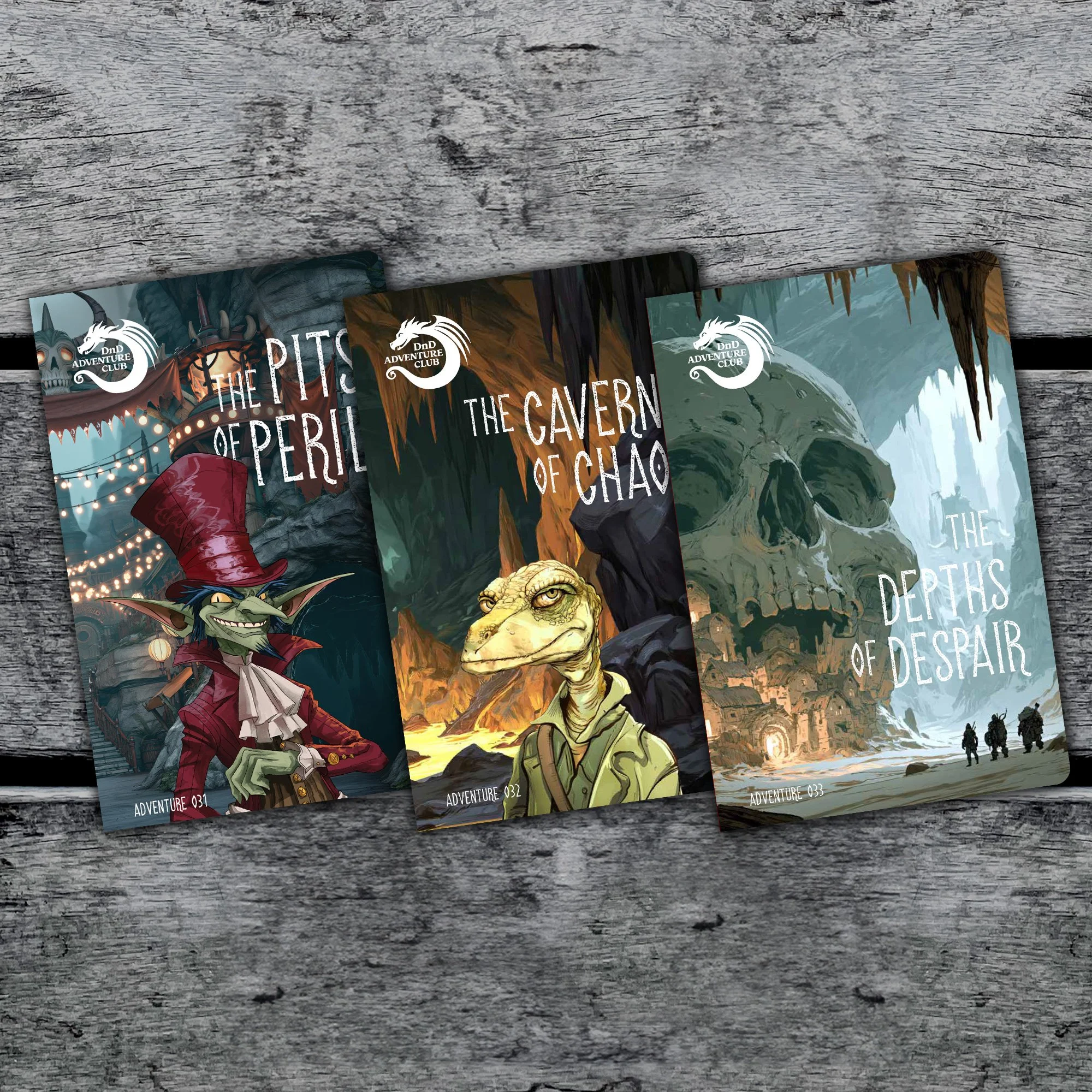 Three adventure-themed book covers titled 'The Caverns of Chaos,' 'The Pits of Peril,' and 'The Depths of Despair,' featuring fantasy artwork with creatures, caves, and ruins, placed on a wooden surface.