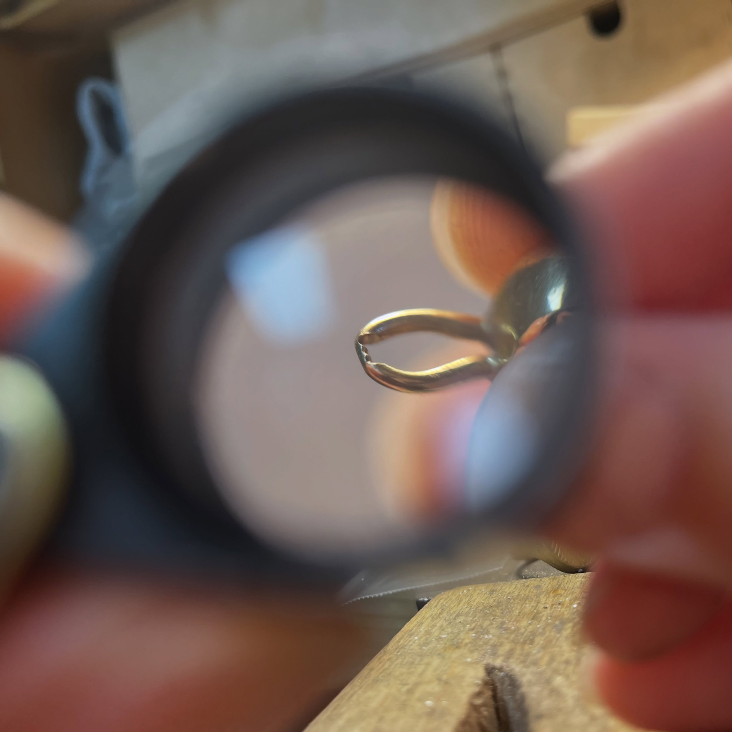 Using a jeweller&rsquo;s loupe to show you a magnified view of the bail on my everyday pendant. Even though it is quite lightweight, constant friction and back&amp;forth contact with the chain has worn away the underside of the bail, which was made w