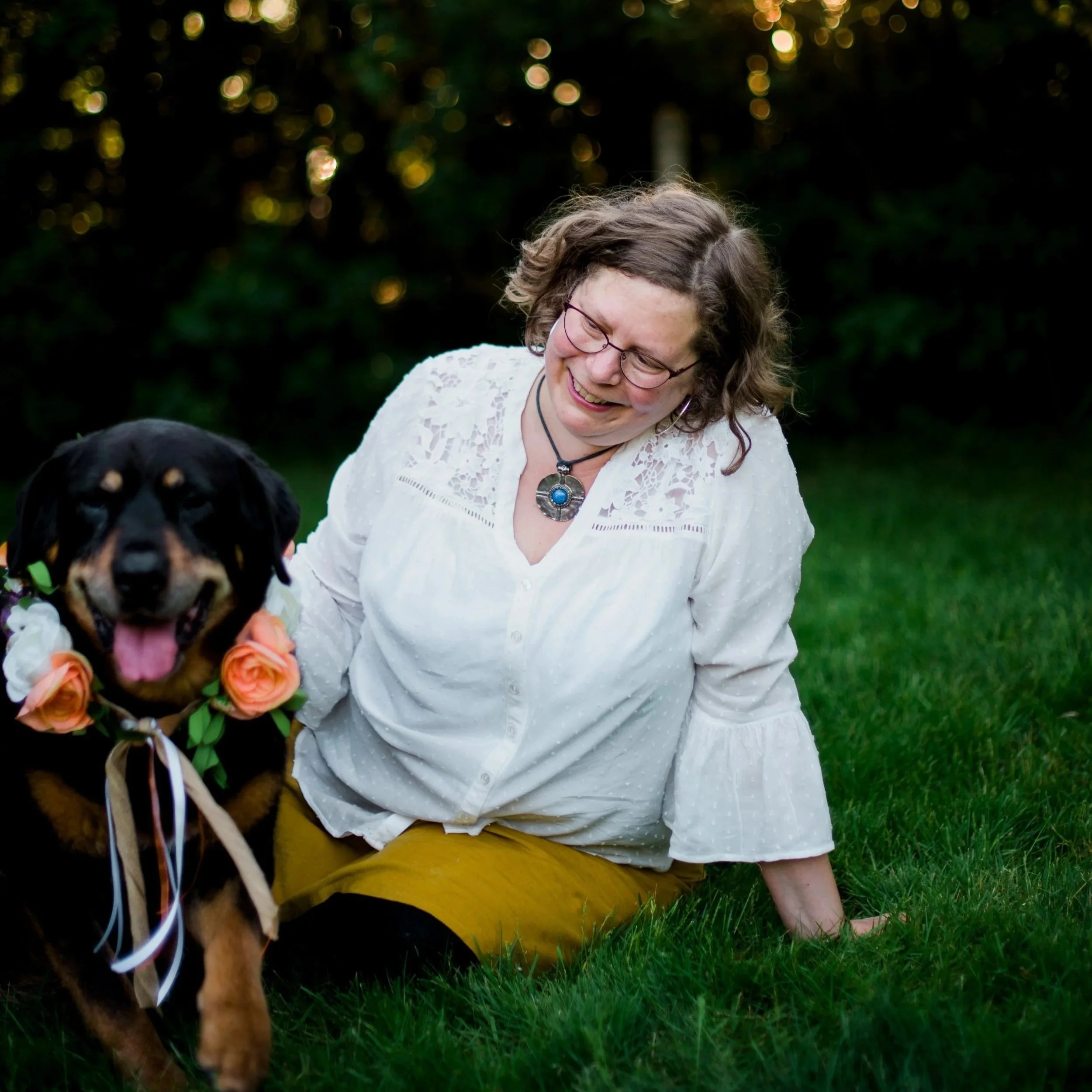 Joanna the Animal Communicator hugging her dog in the garden