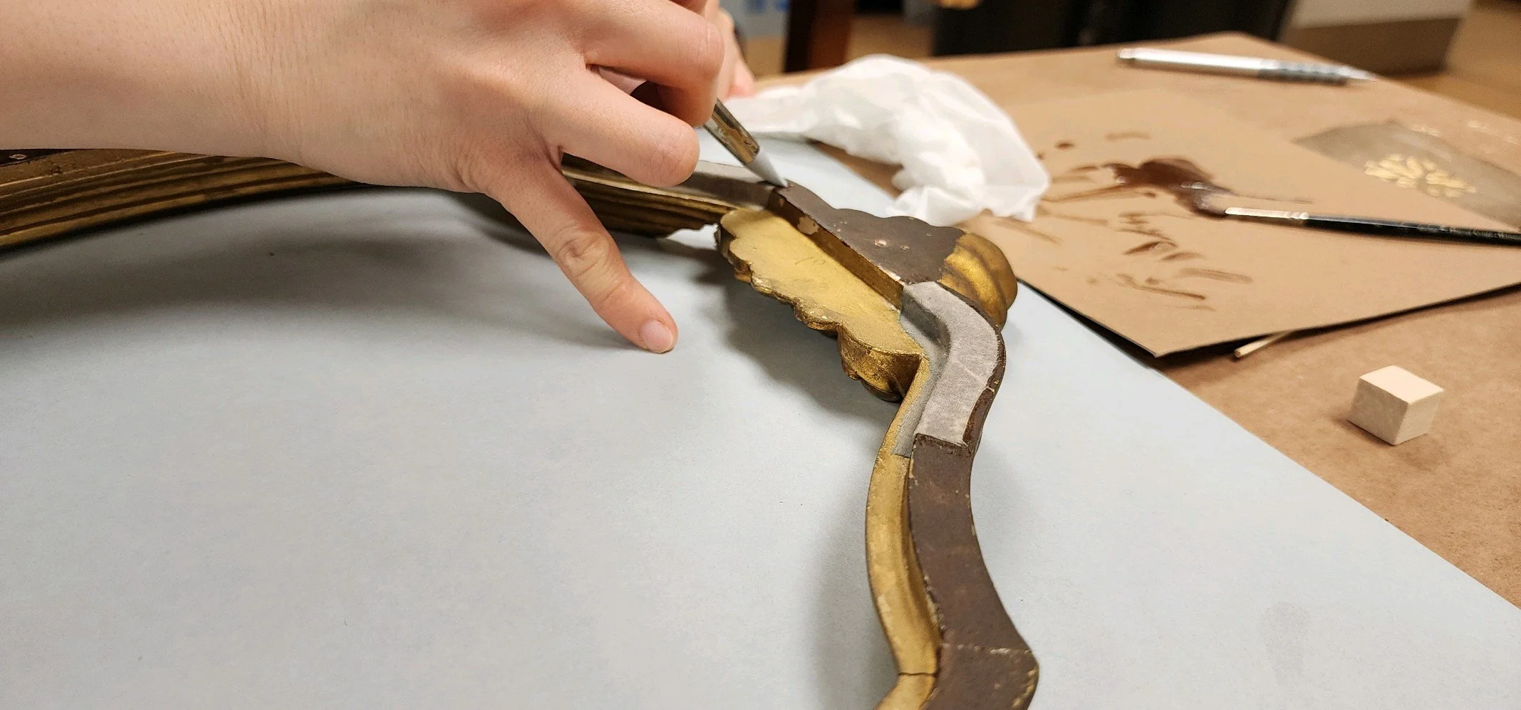 Tacking down the muslin strip and squeezing out excess hide glue with a silicone applicator. Blue corrosion beginning to appear. (Photo: David Piurek)
