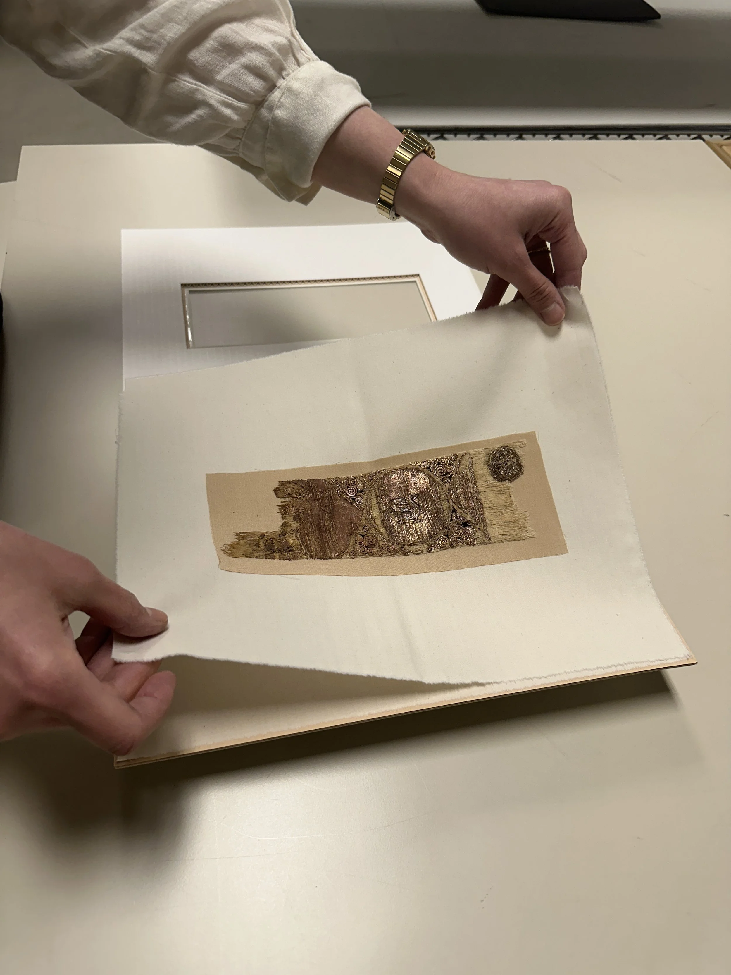 Carla demonstrating how the textile fragment can be handled without touching it directly with the new mat. (Photo: Jennifer Kim)