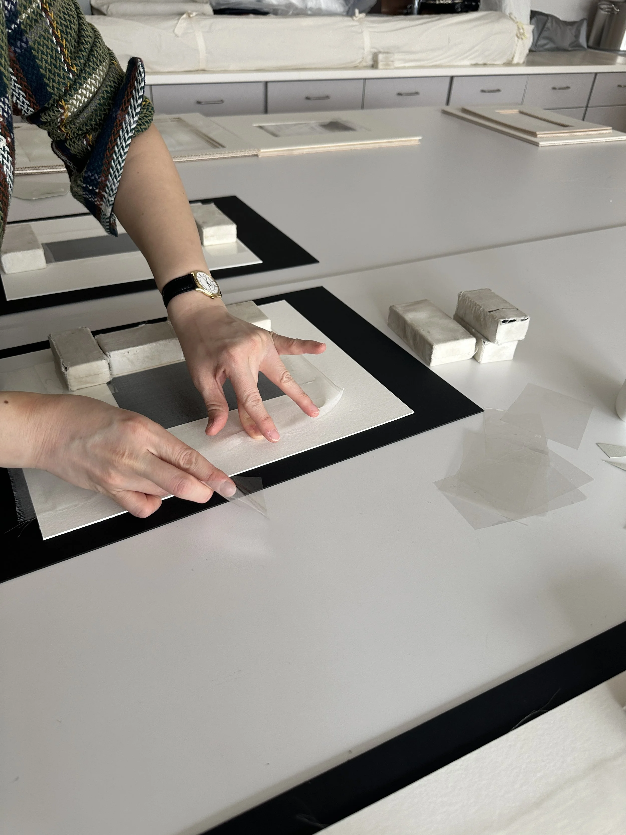 Stretching out the sides of the crepeline on the window while the adhesive is still wet. (Photo: Carla Fontecchio)