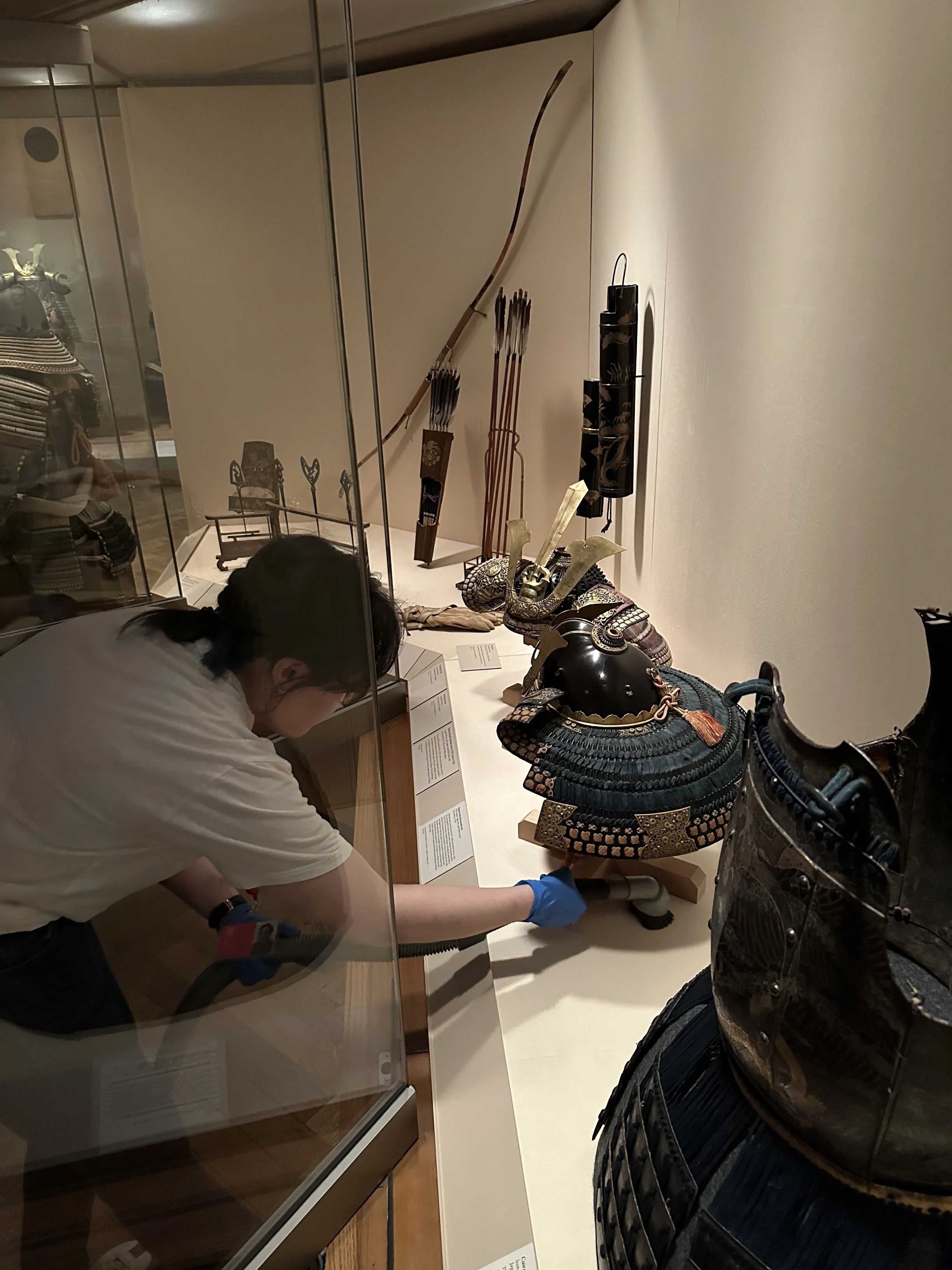 Vacuuming a display case. (Photo: Sean Belair)
