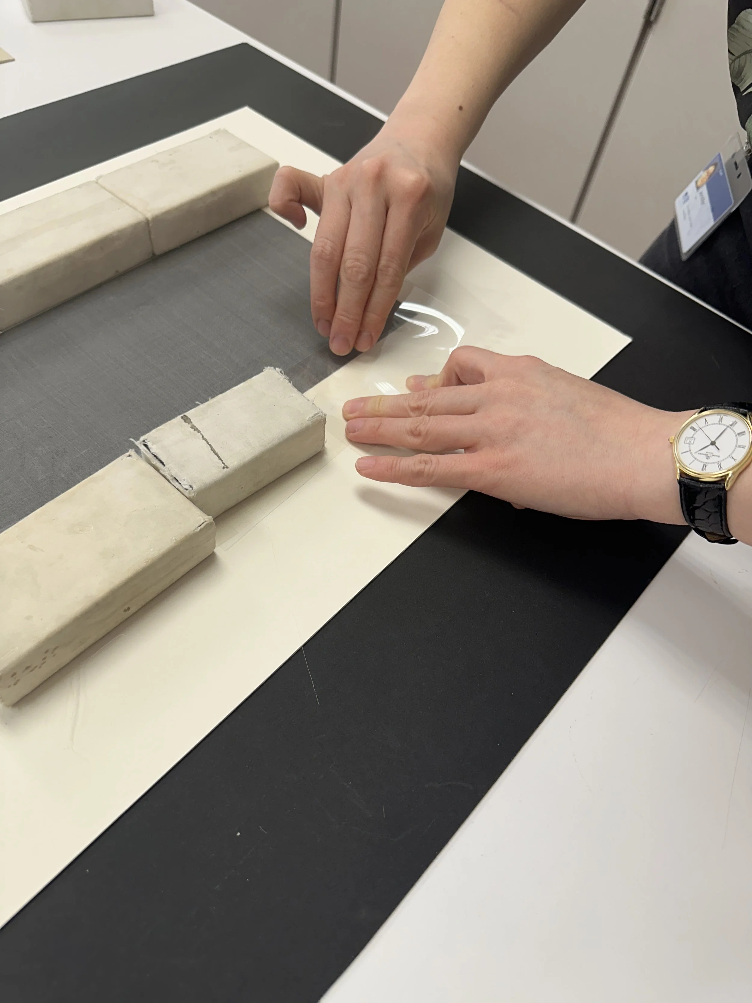 Laying down the mylar on the still-wet adhesive and crepeline. (Photo: Carla Fontecchio)