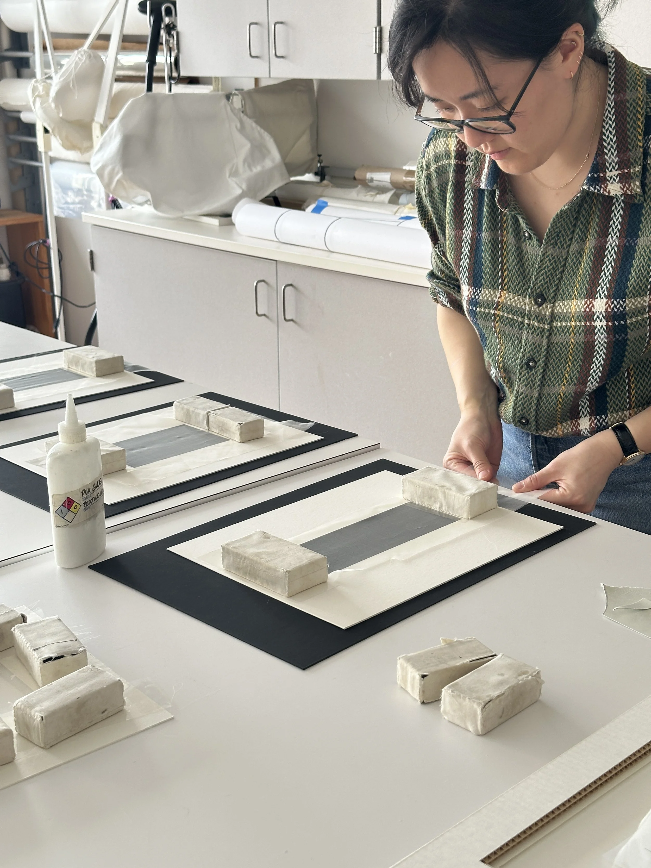 Stretching out the length of the crepeline window while the adhesive is still wet. (Photo: Carla Fontecchio)