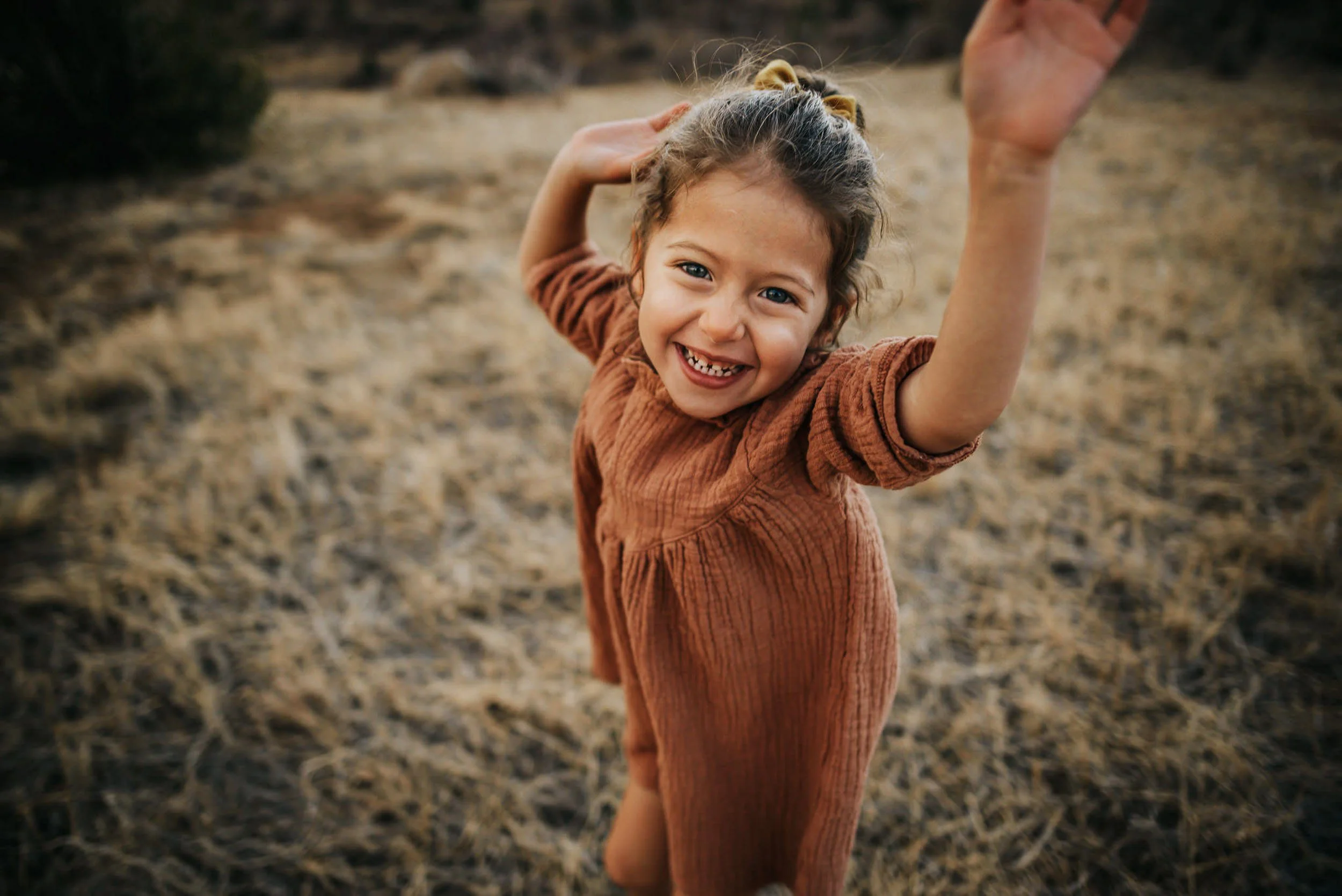 A little girl throws her hands up in the air from excitement at Stratton Open Space.
