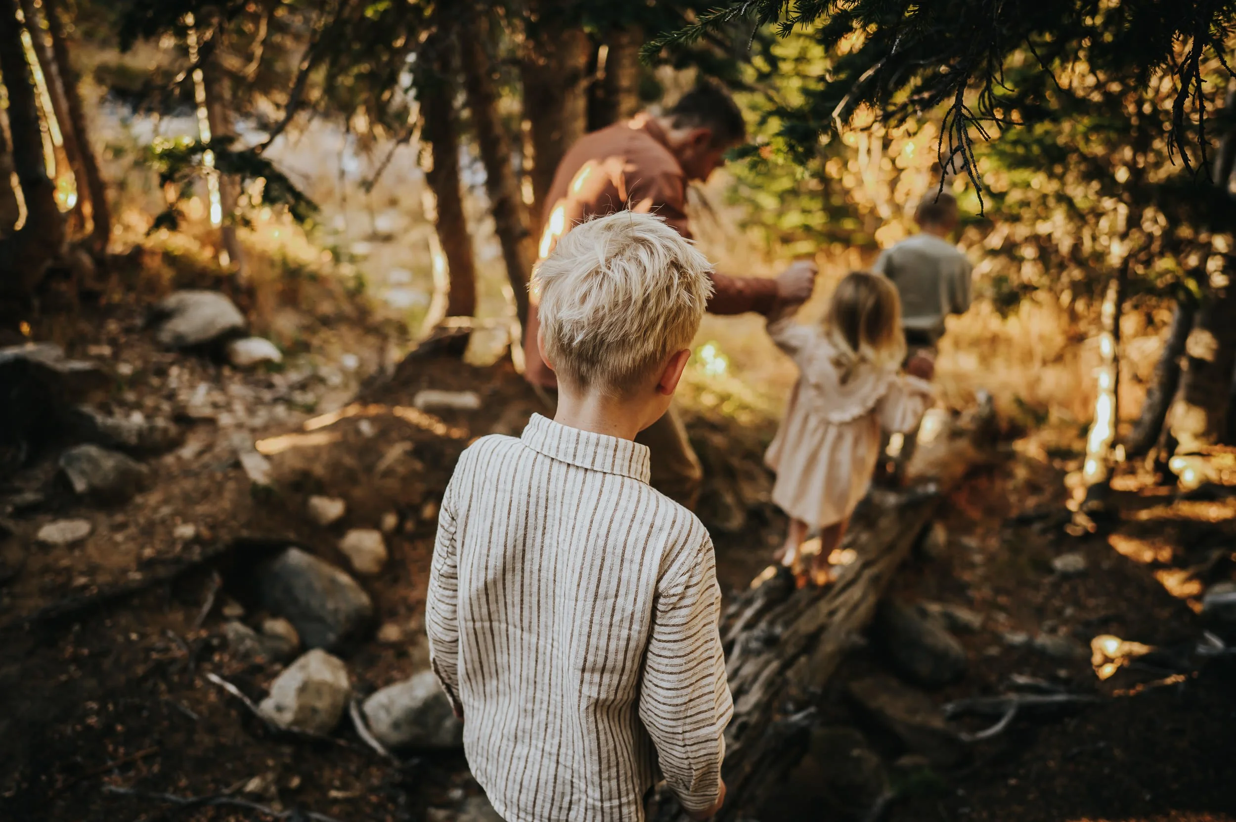 Children running along a forest trail during a playful family photo session at Brainard Lake.