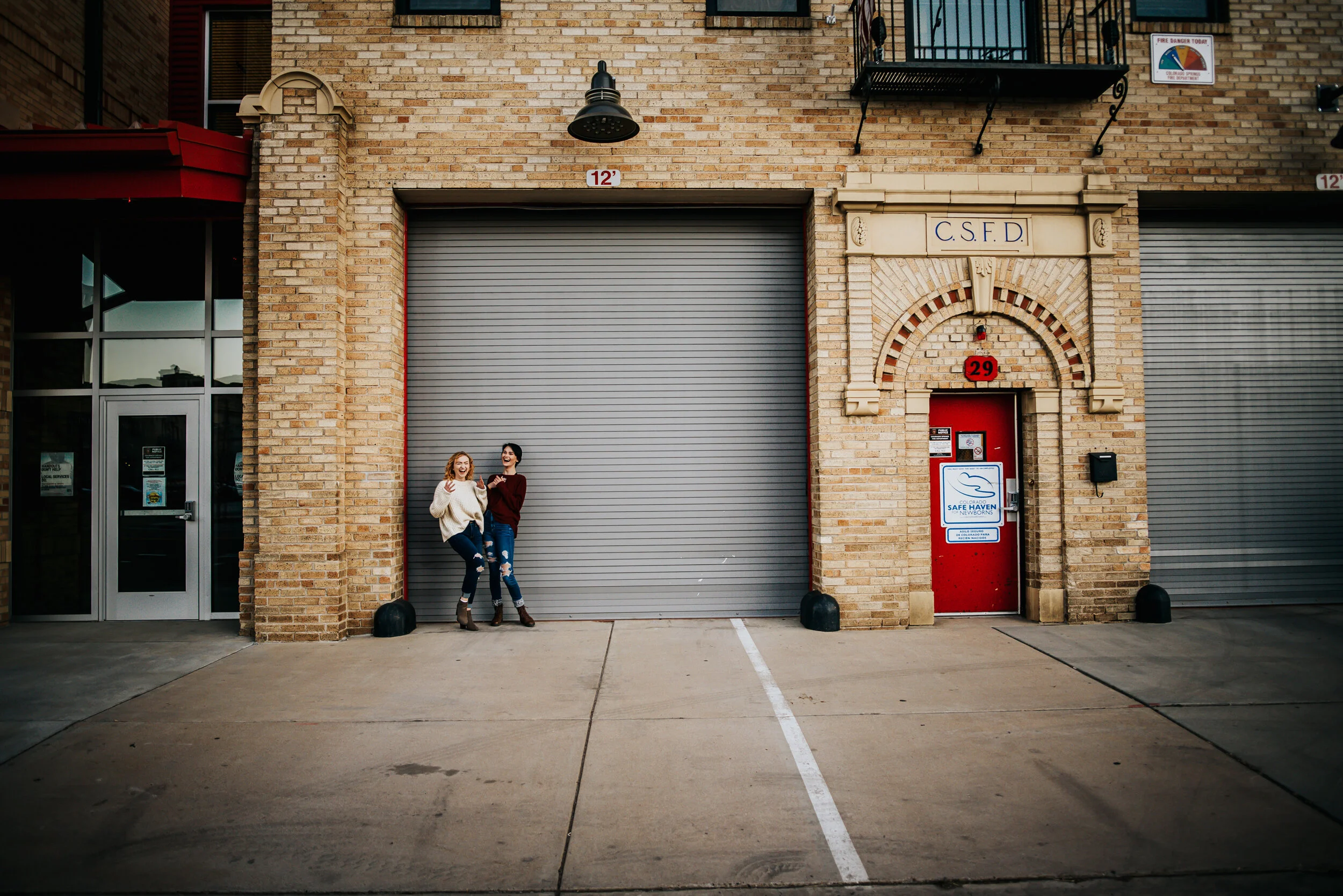 Siblings together in downtown Colorado Springs with brick walls and urban texture.