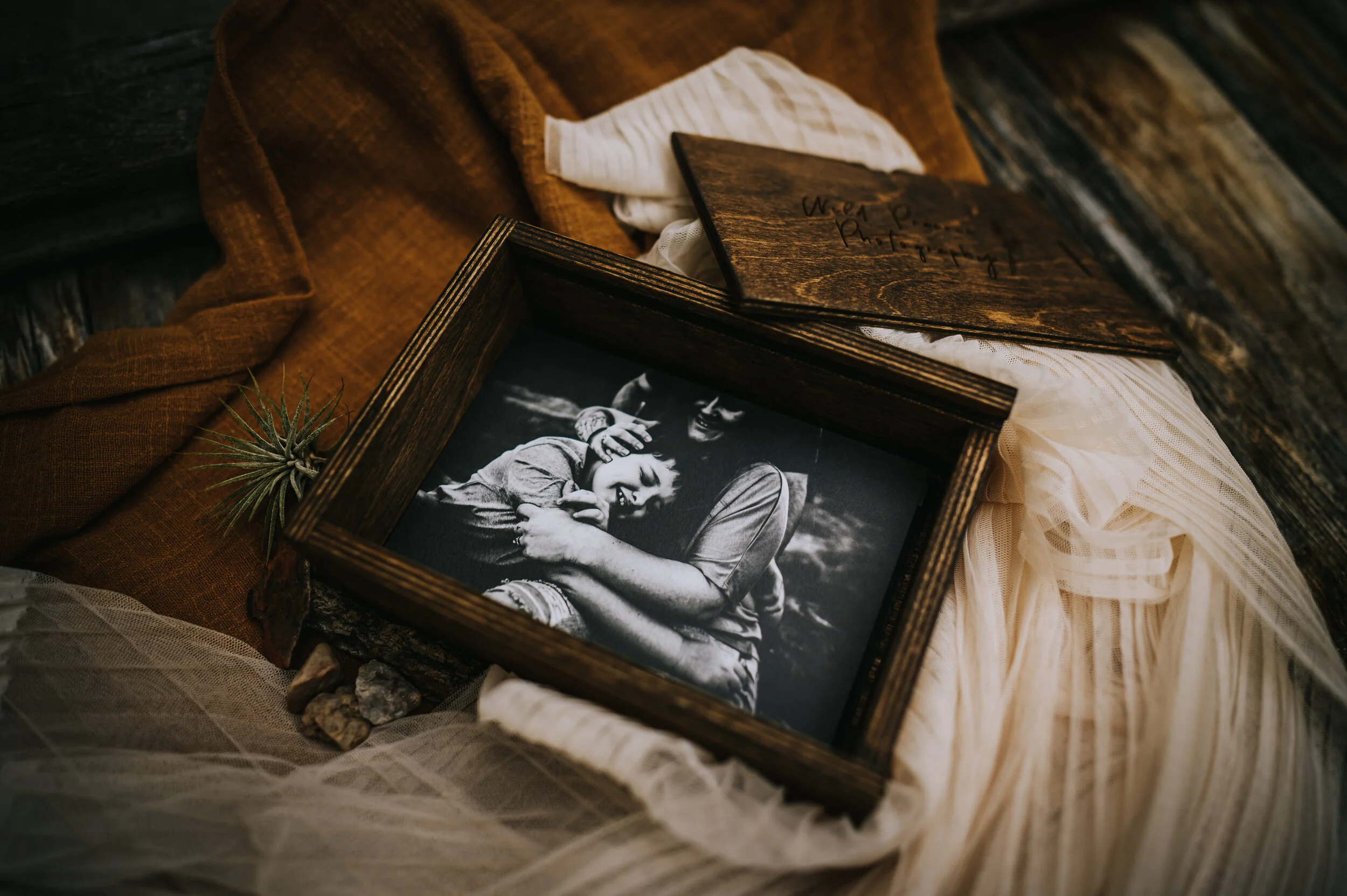 Open wooden box displaying family session prints.