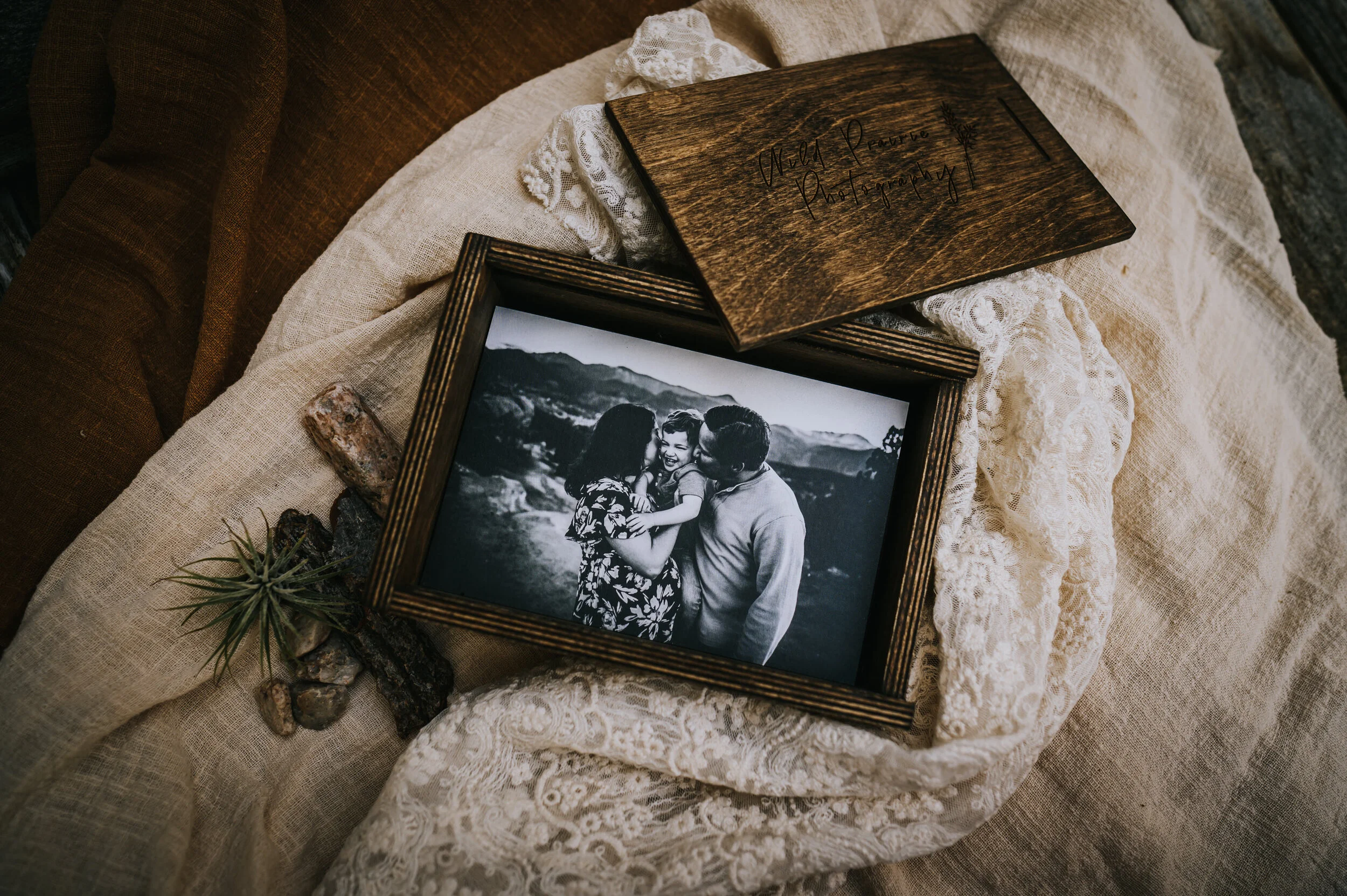 Open wooden box displaying a framed family portrait.