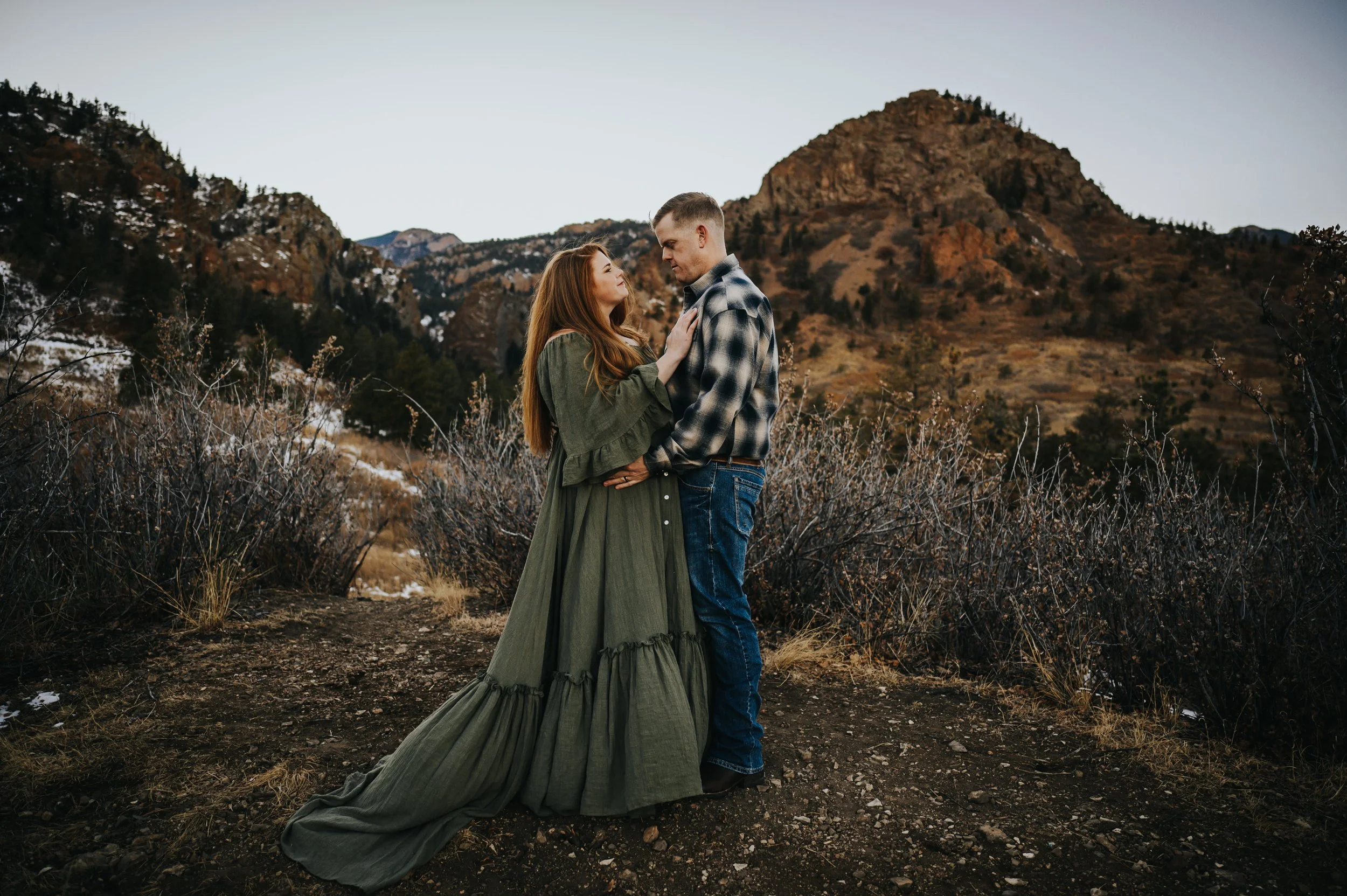 Maternity session with Colorado mountains rising in the background at sunset.