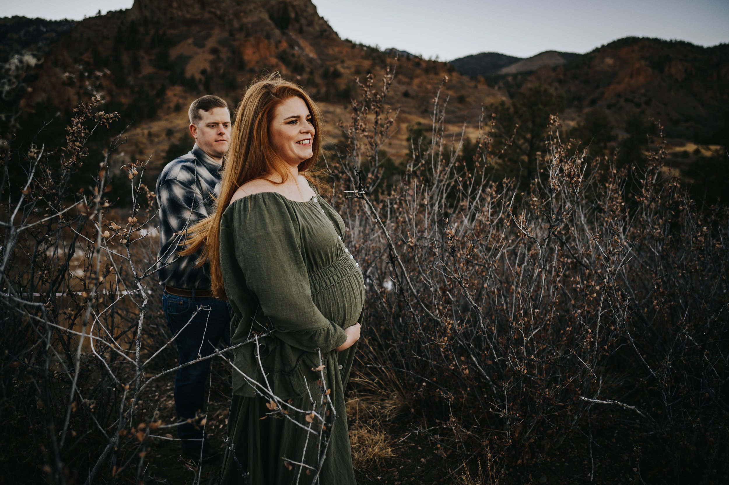 Couple laughing together in golden evening light during Cheyenne Canon maternity session.