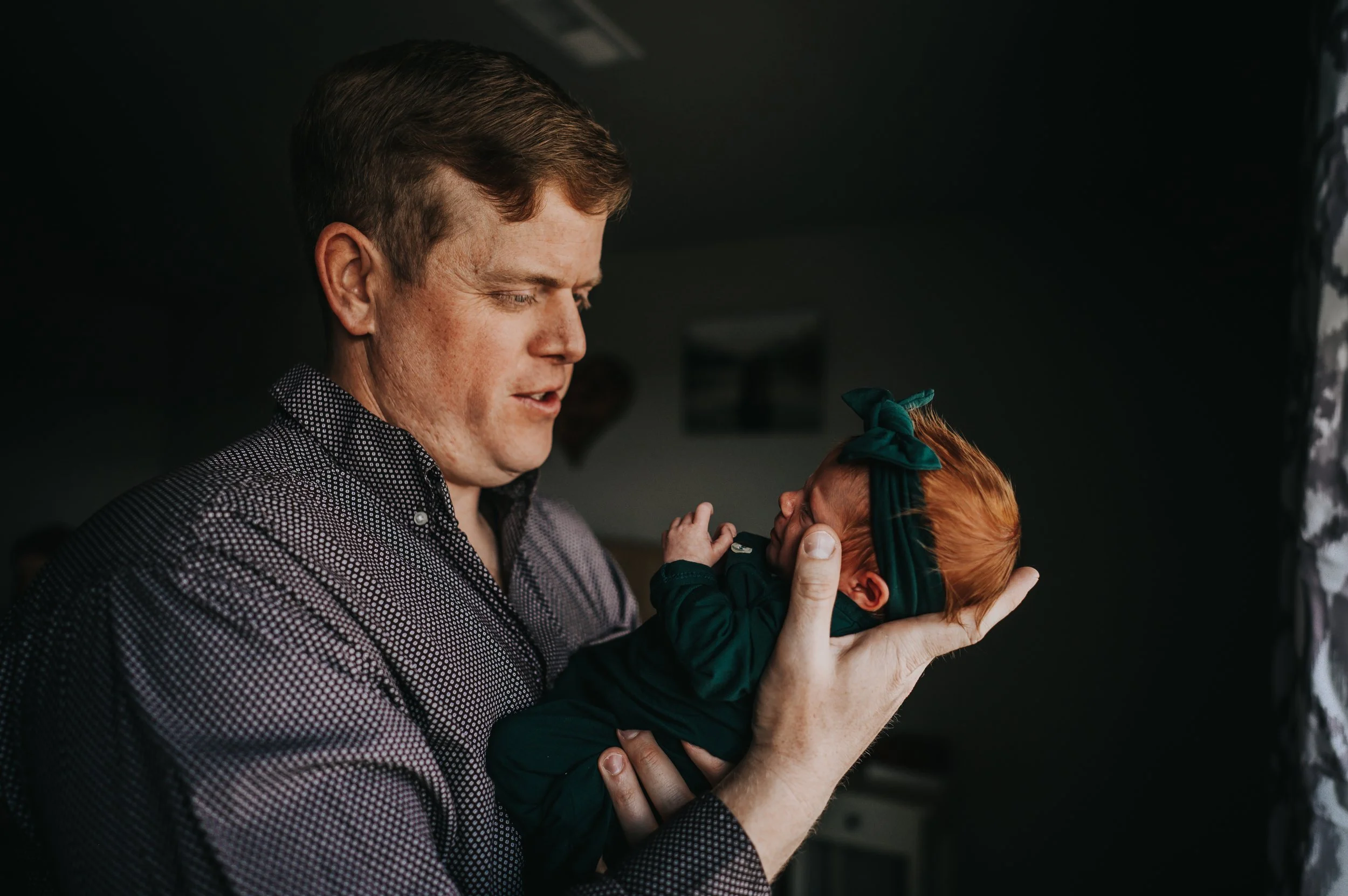 Parents snuggled together with newborn baby Sawyer during lifestyle newborn session.