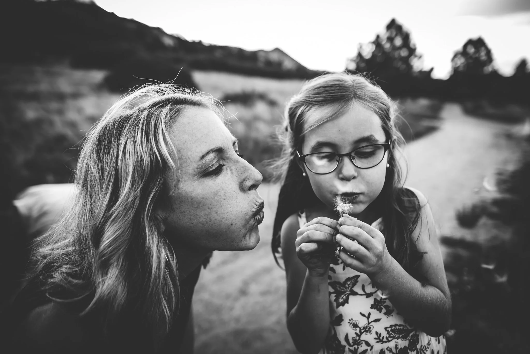 A mother and her daughter blow away the seeds from a sprouted wild flower at Ute Valley Park in Colorado Springs.