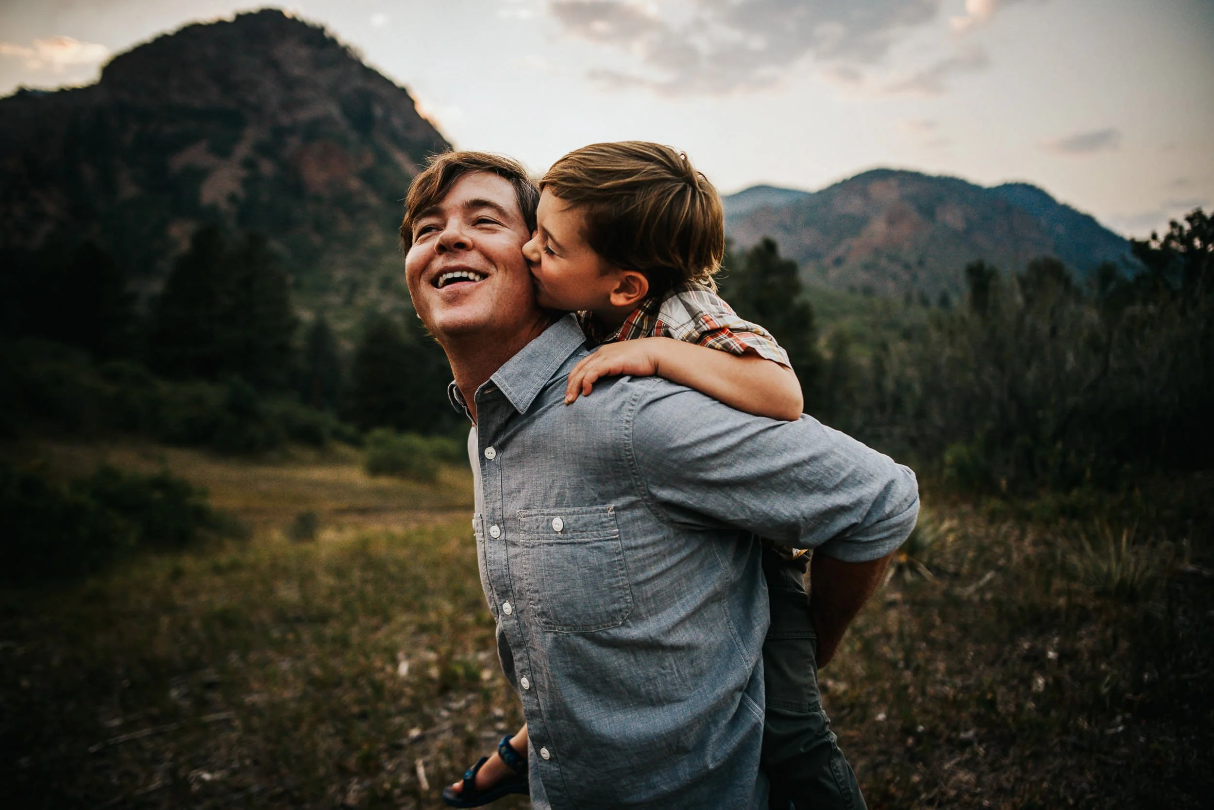 son-kisses-dads-cheek-mountains.jpg