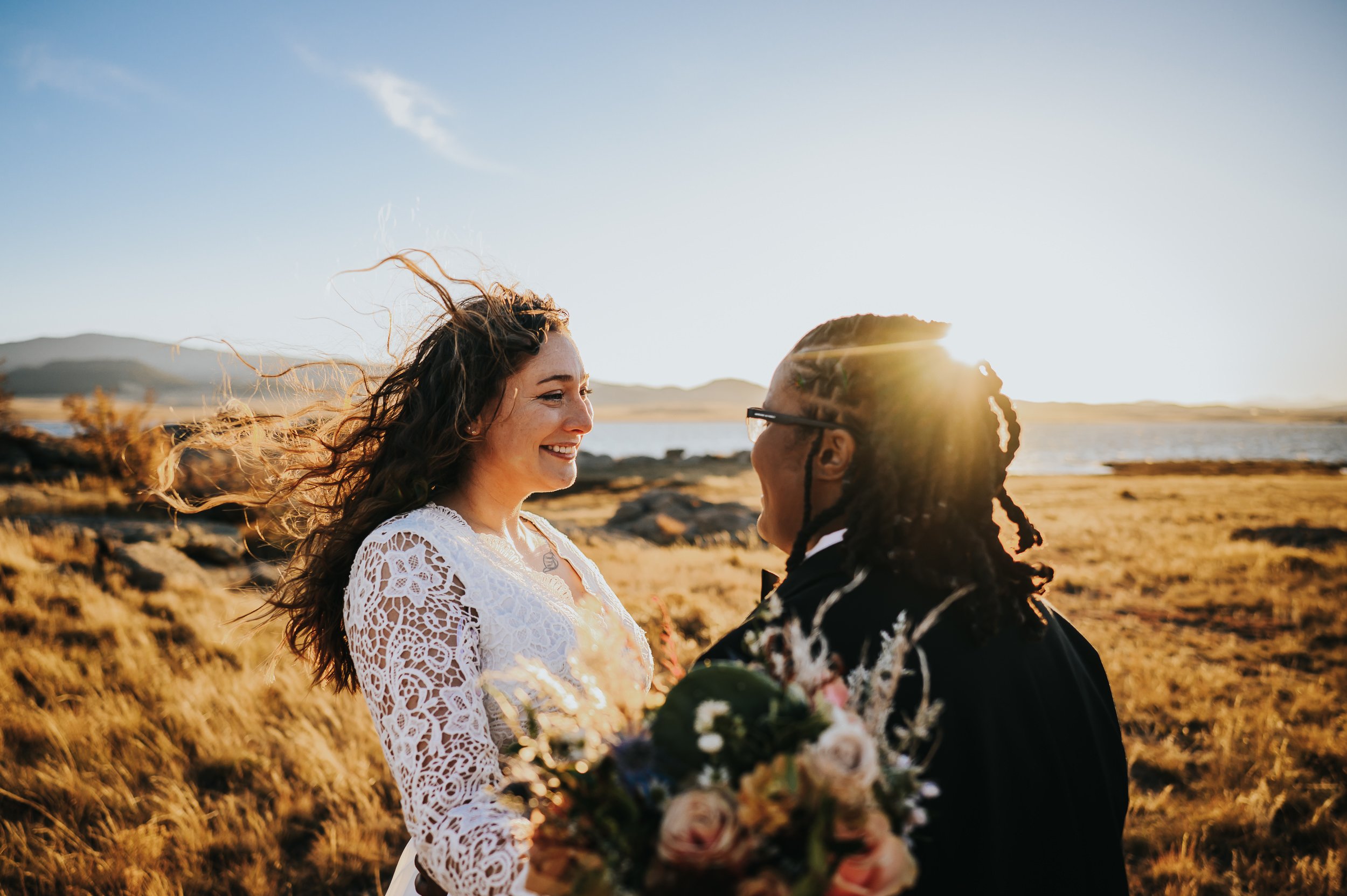 Bride seeing her partner for the first time in wedding clothes, golden light surrounding them.