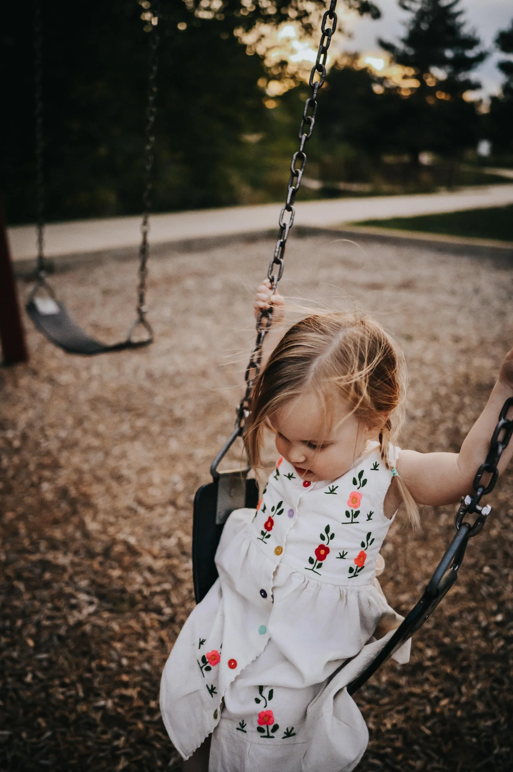 Two-year-old toddler swinging on a swing during a family photo session in Denver.