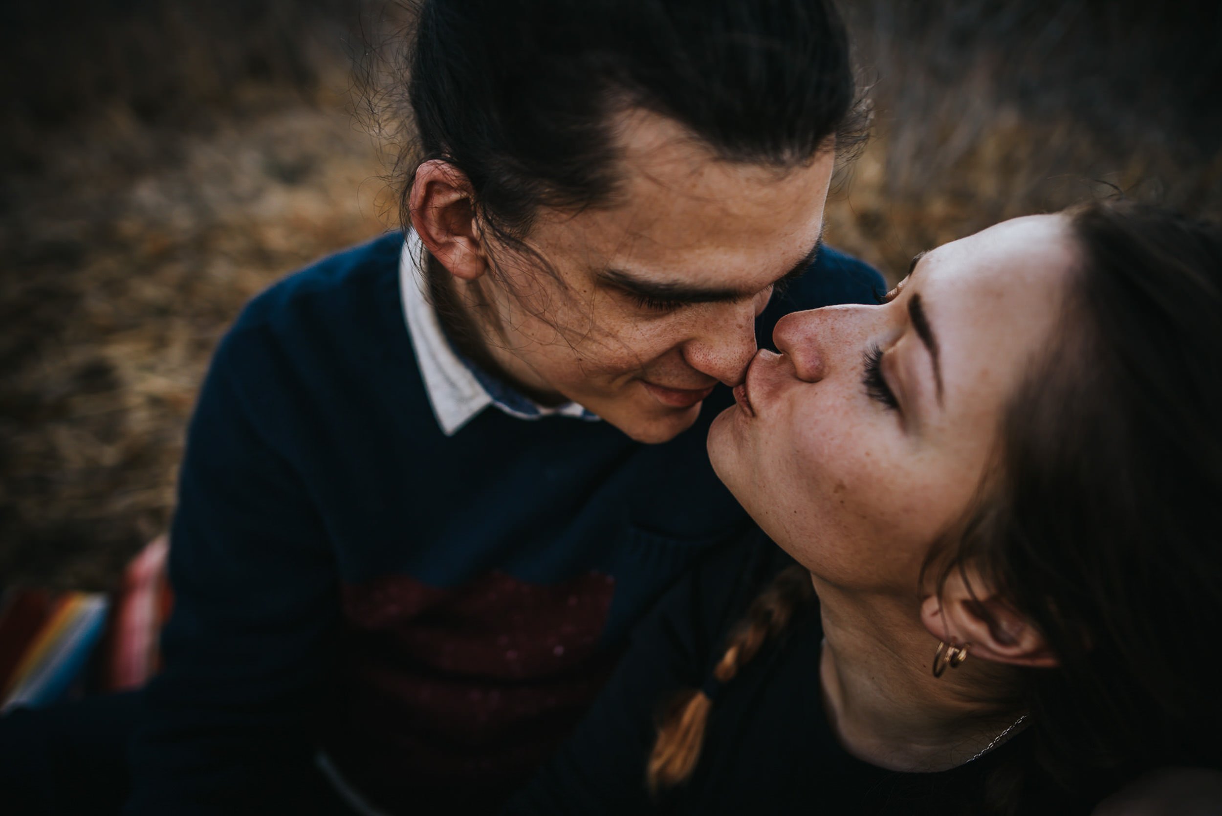 A couple leans forehead to forehead, eyes closed, in a tender closeup portrait.