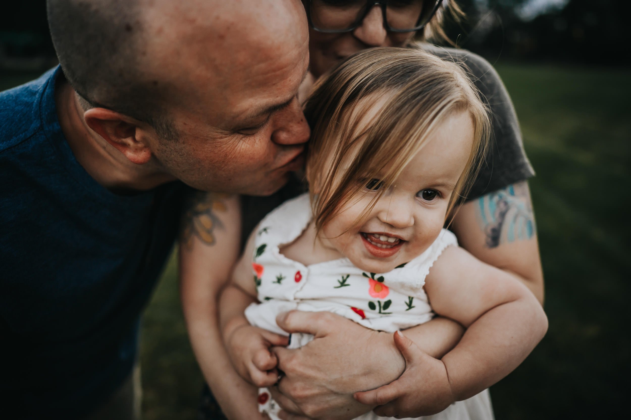 Father playing with his toddler daughter during a natural family photography session in Denver.