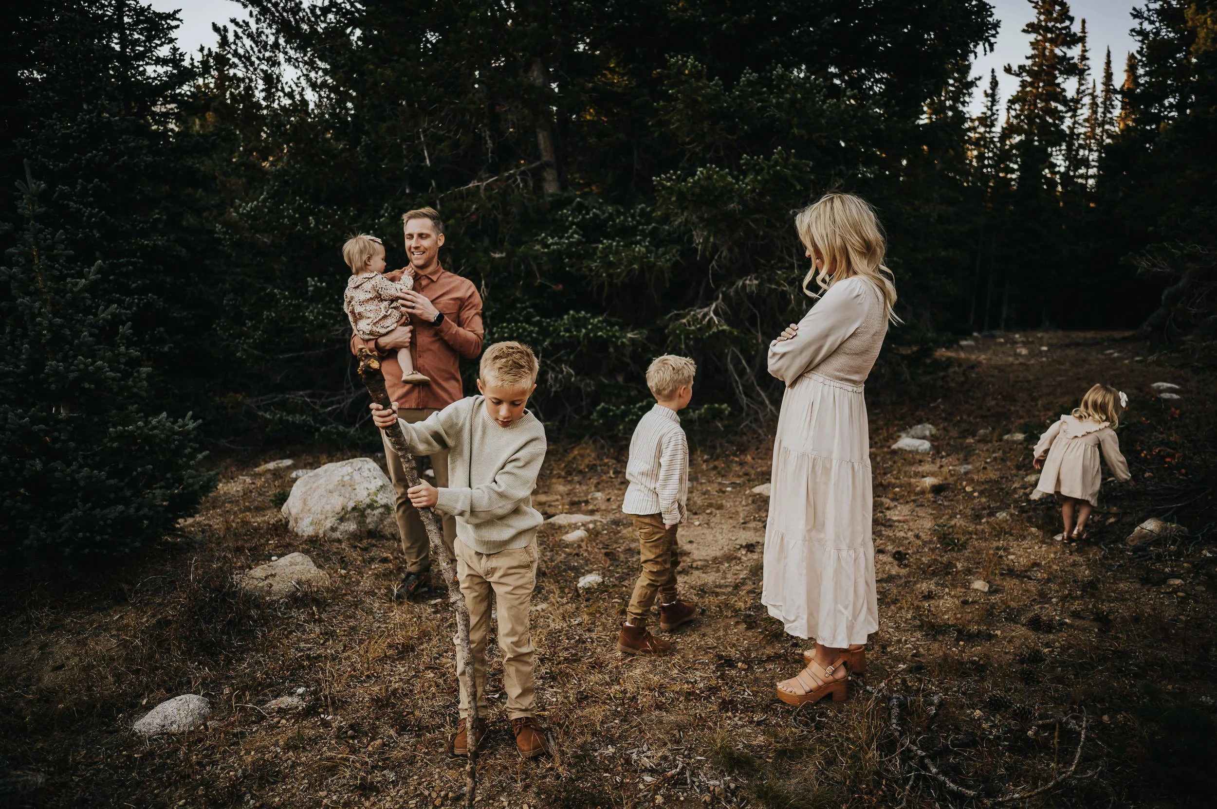 Wide landscape view of family framed by mountains at Brainard Lake during golden hour.